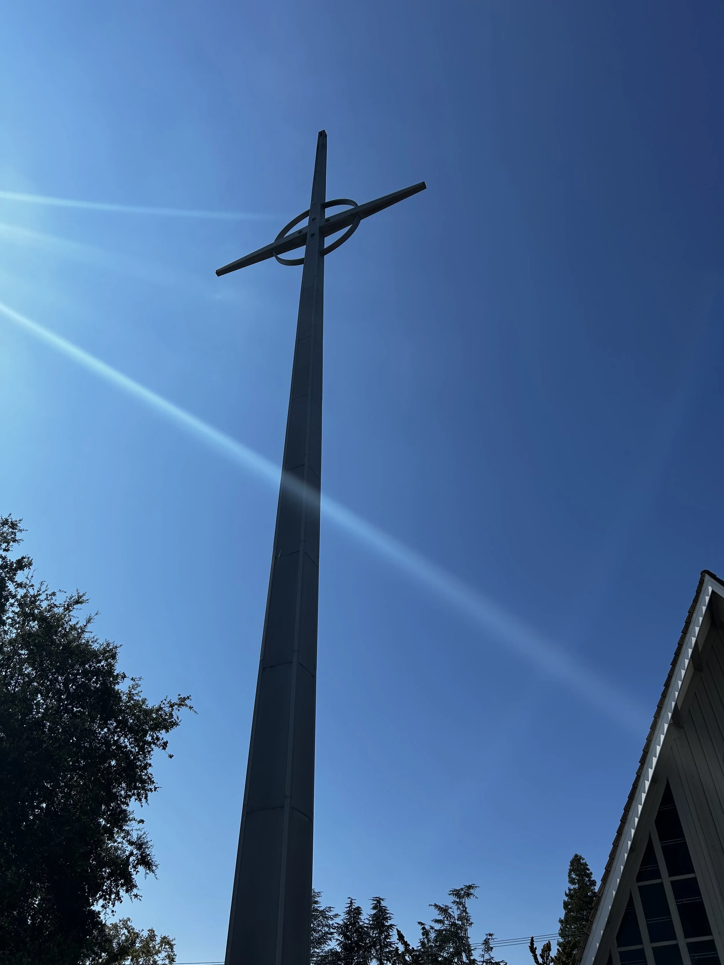Cross at First Presbyterian Church of Mountain View silhouetted against a blue sky