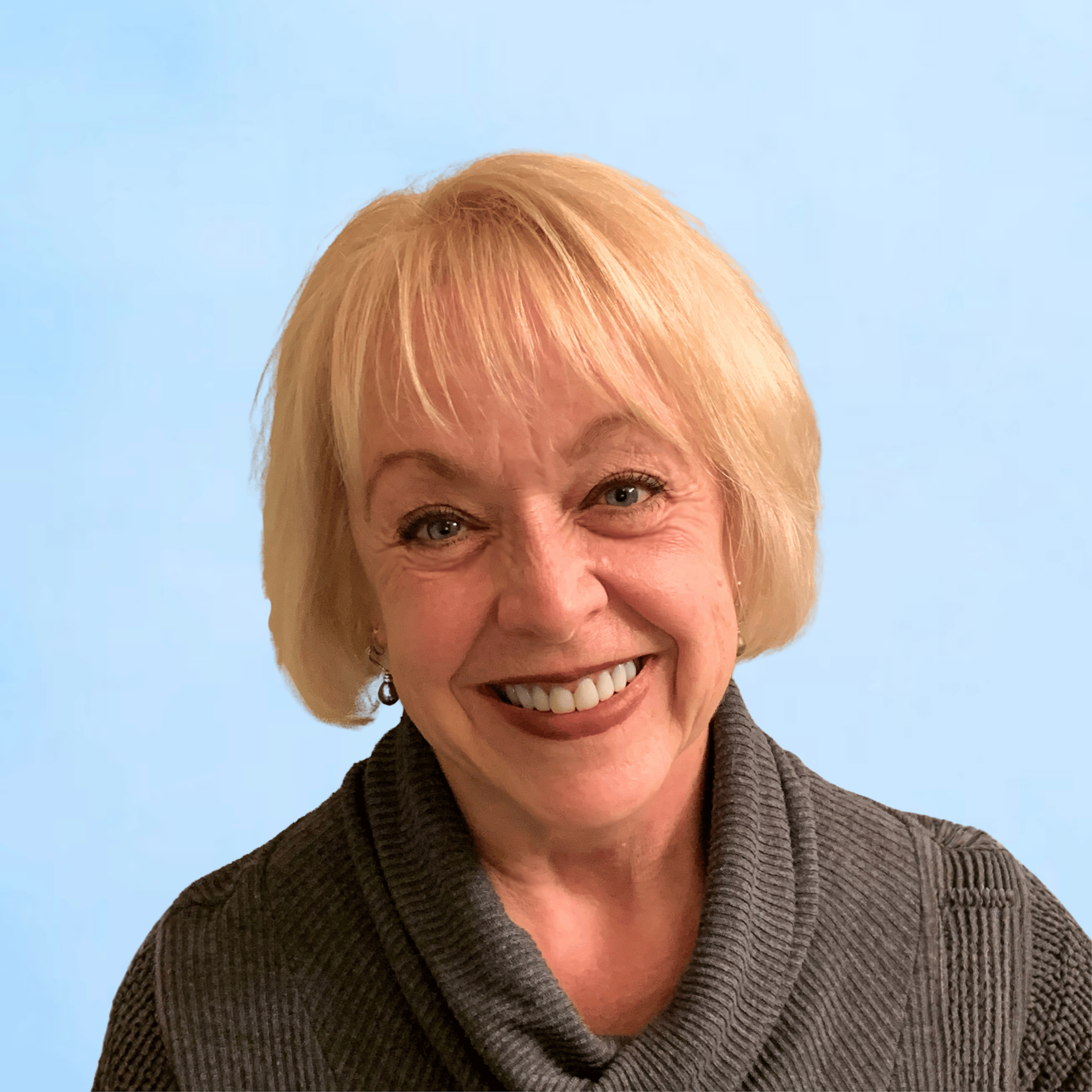 Pastor Kim smiling, wearing a dark gray sweater, against a light blue background.