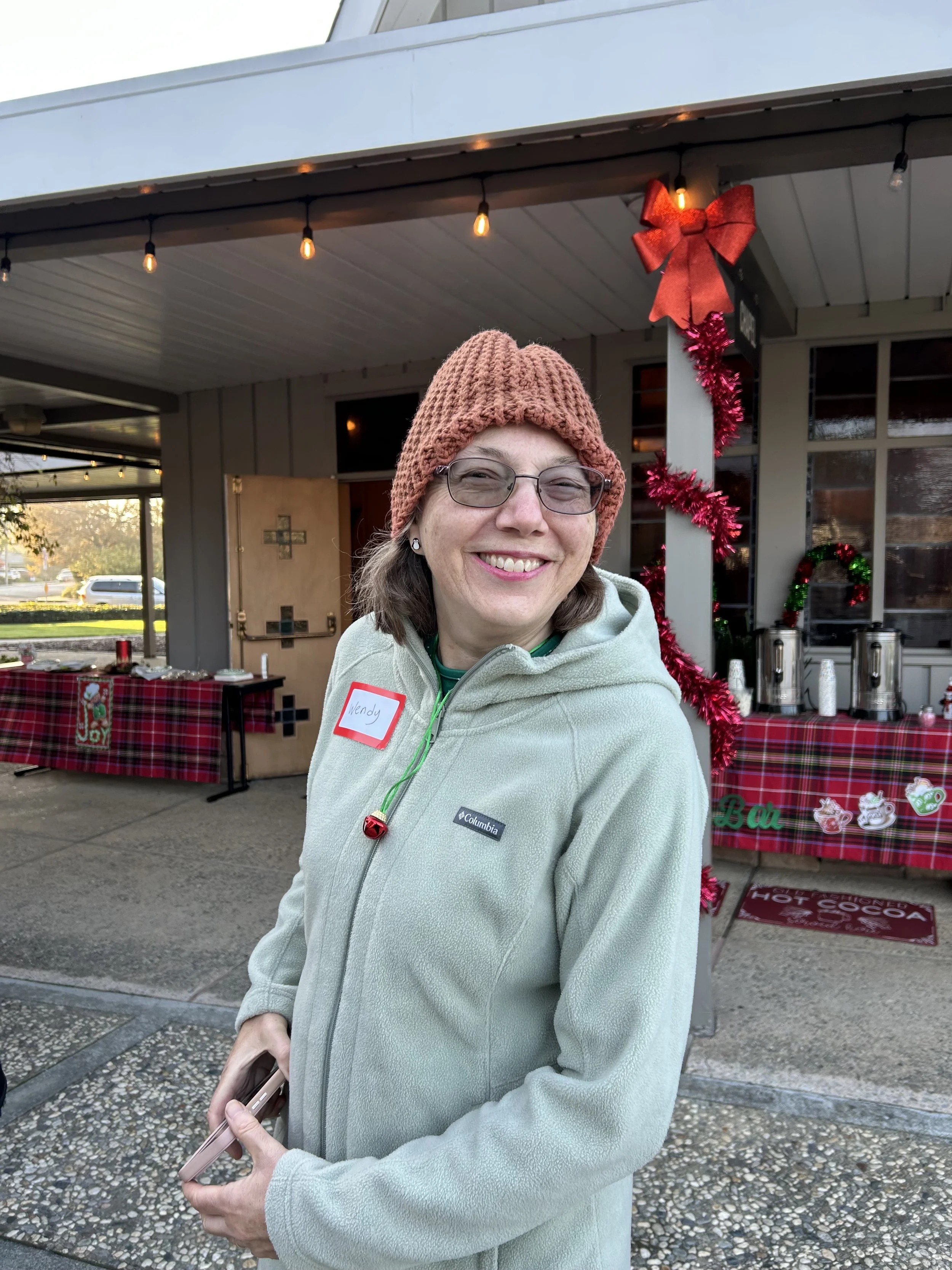 Church volunteer smiling at Christmas event on the church patio
