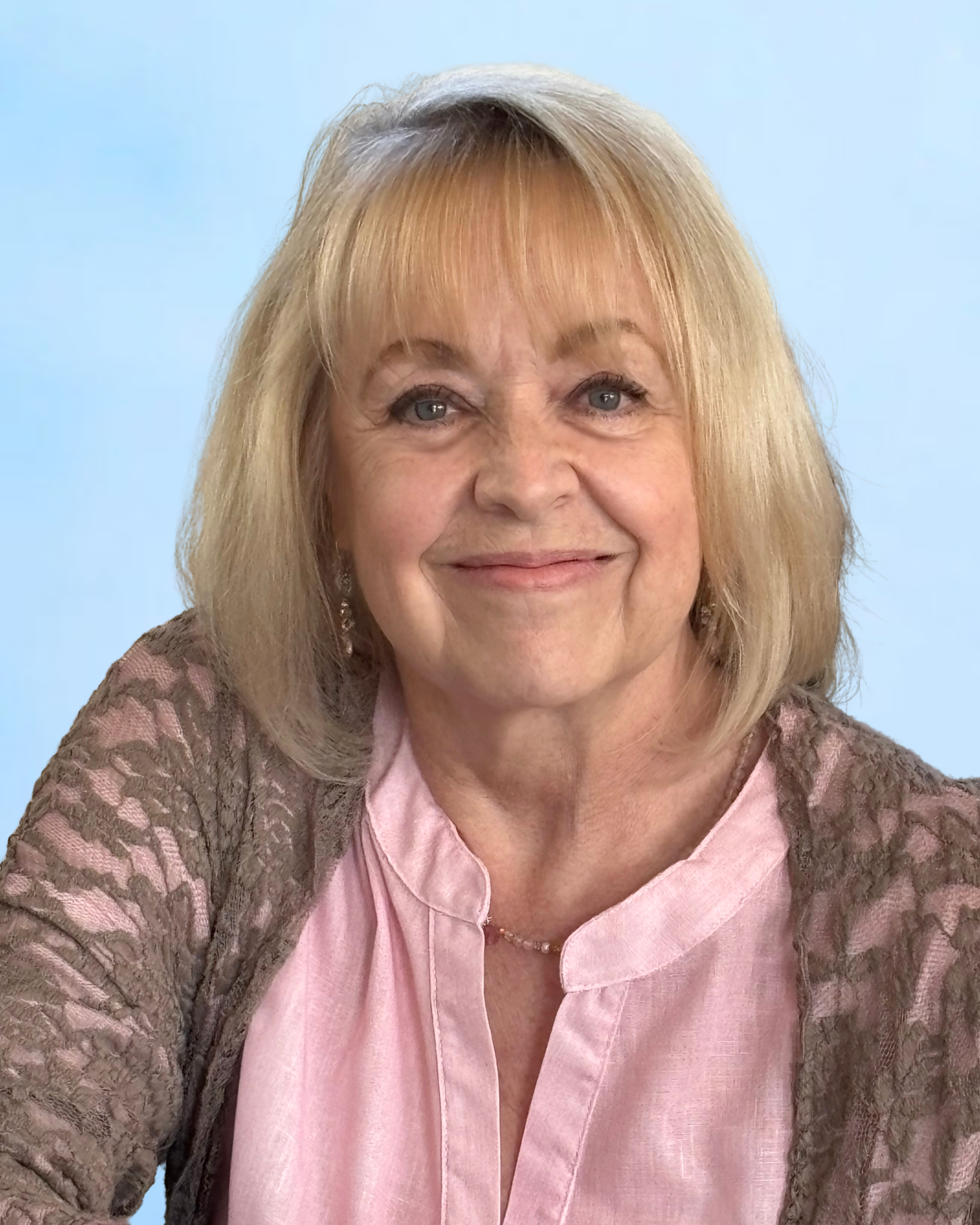 Pastor Kim smiling, wearing a dark gray sweater, against a light blue background.