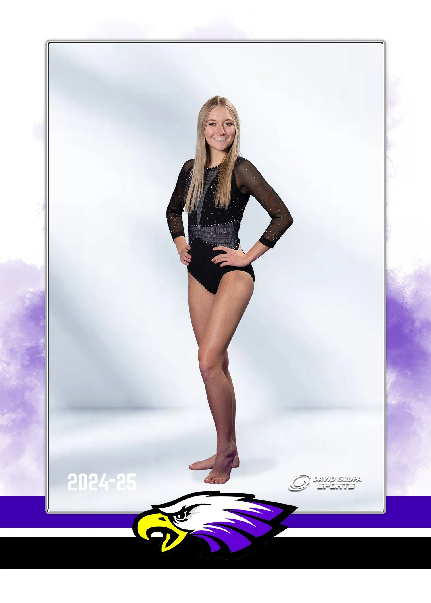 A young woman in a black gymnastics leotard with sheer sleeves, standing on a white background, smiling with hands on hips.