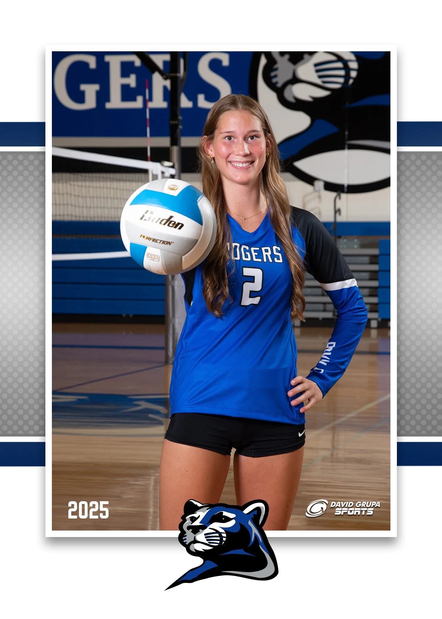 A young female volleyball player in a blue and black jersey holding a volleyball in a gymnasium, smiling at the camera. The jersey has the number 2 and the word 'ROGERS'. The background features a gym with a volleyball net and a sign with the word 'G