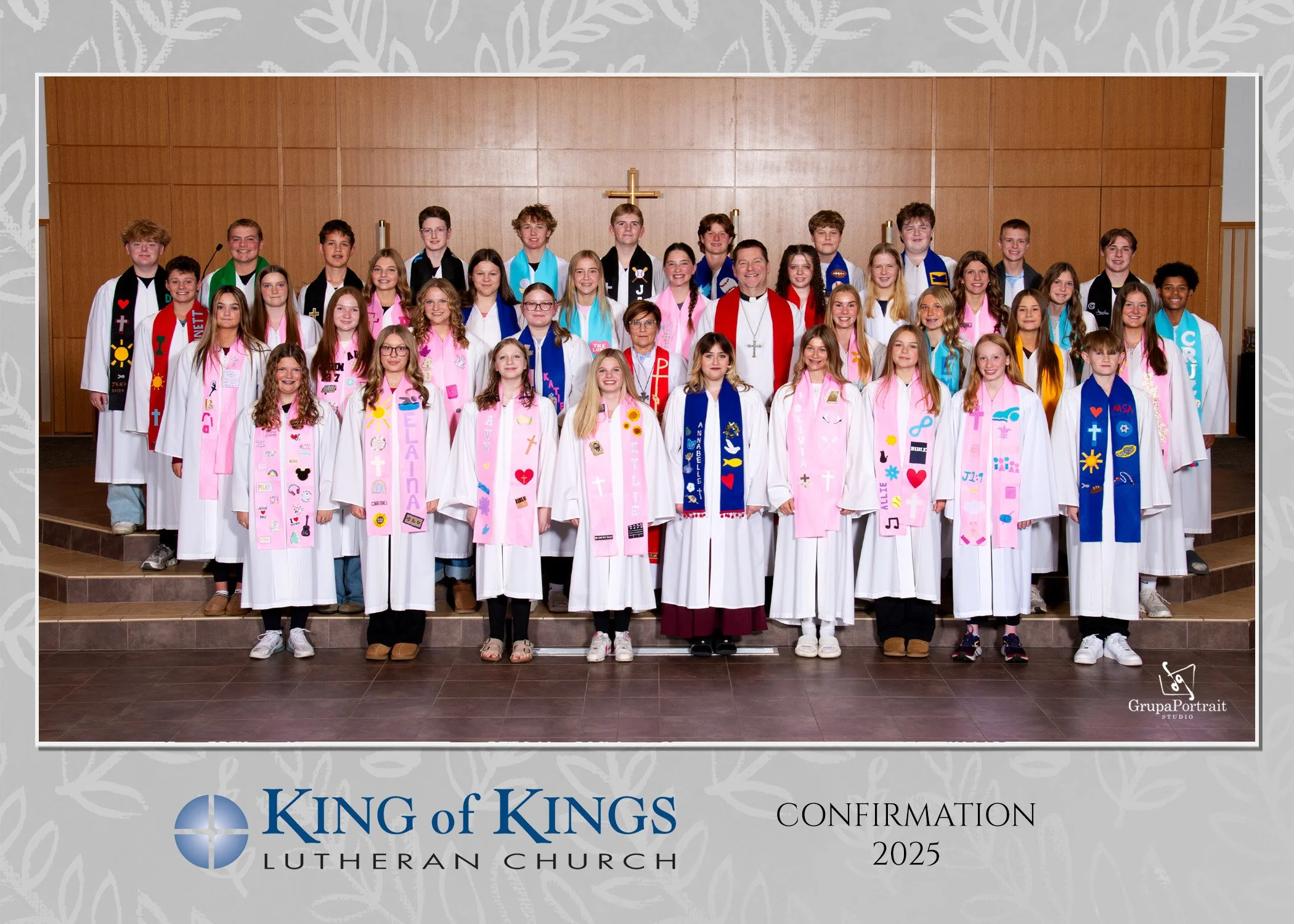 Group of children and adults dressed in white robes with colorful handmade stoles, gathered on church stage for a confirmation ceremony at King of Kings Lutheran Church in 2025.