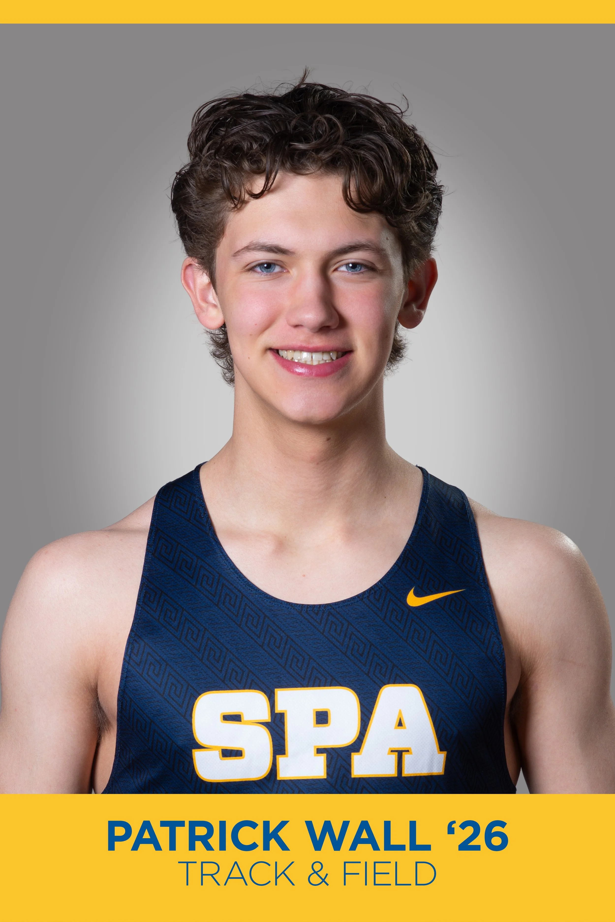 A young male athlete with curly brown hair and blue eyes, smiling, wearing a blue track and field uniform with 'SPA' and a yellow Nike logo. The background is grey with a yellow bar at the top and bottom, featuring text indicating his name is Patrick
