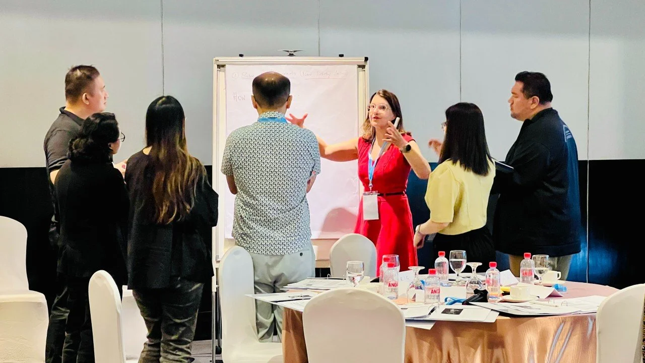 Sabine Lehner facilitating a leadership workshop with a group at a flipchart