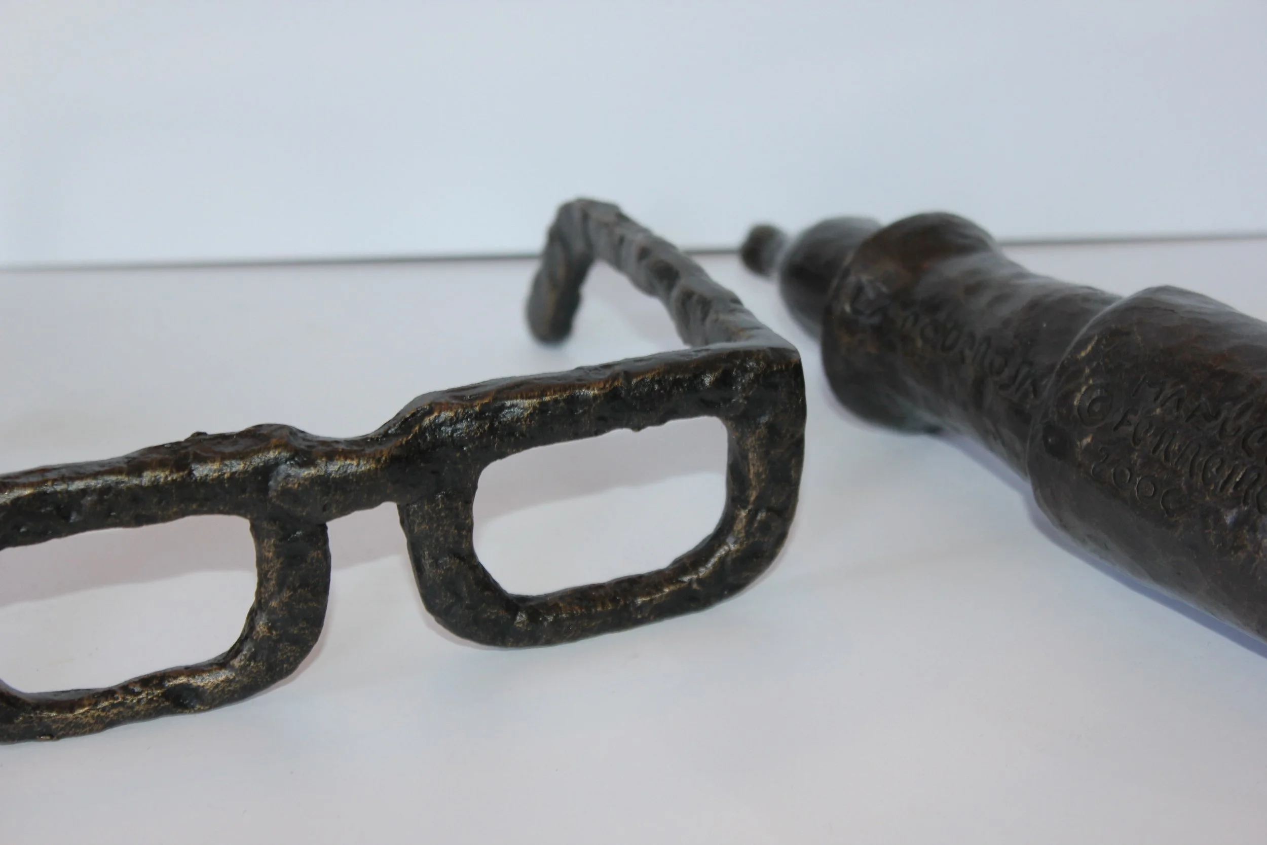 Close-up of an old, rusted metal tool with a twisted handle and a flat, uneven blade on a white background.