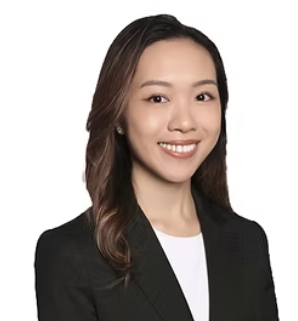 A young woman with long dark hair, wearing a black blazer and white top, smiling against a white background.