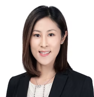 A professional woman smiling, wearing a black blazer and a white top, with shoulder-length dark hair.