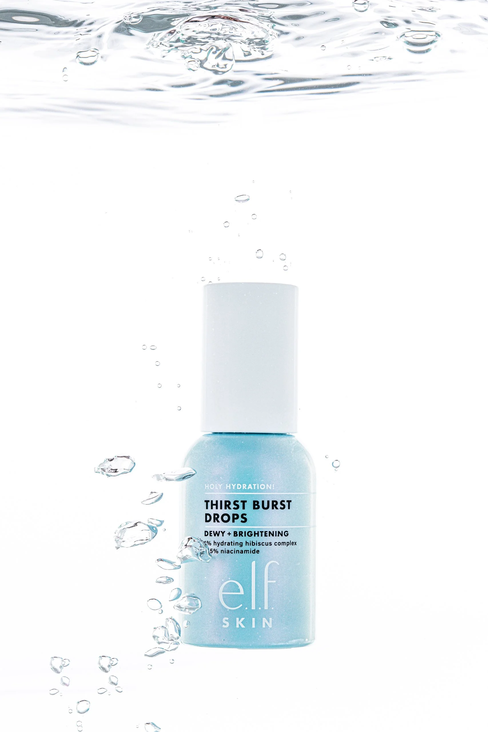 A skincare product bottle surrounded by splashing water droplets against a white background.
