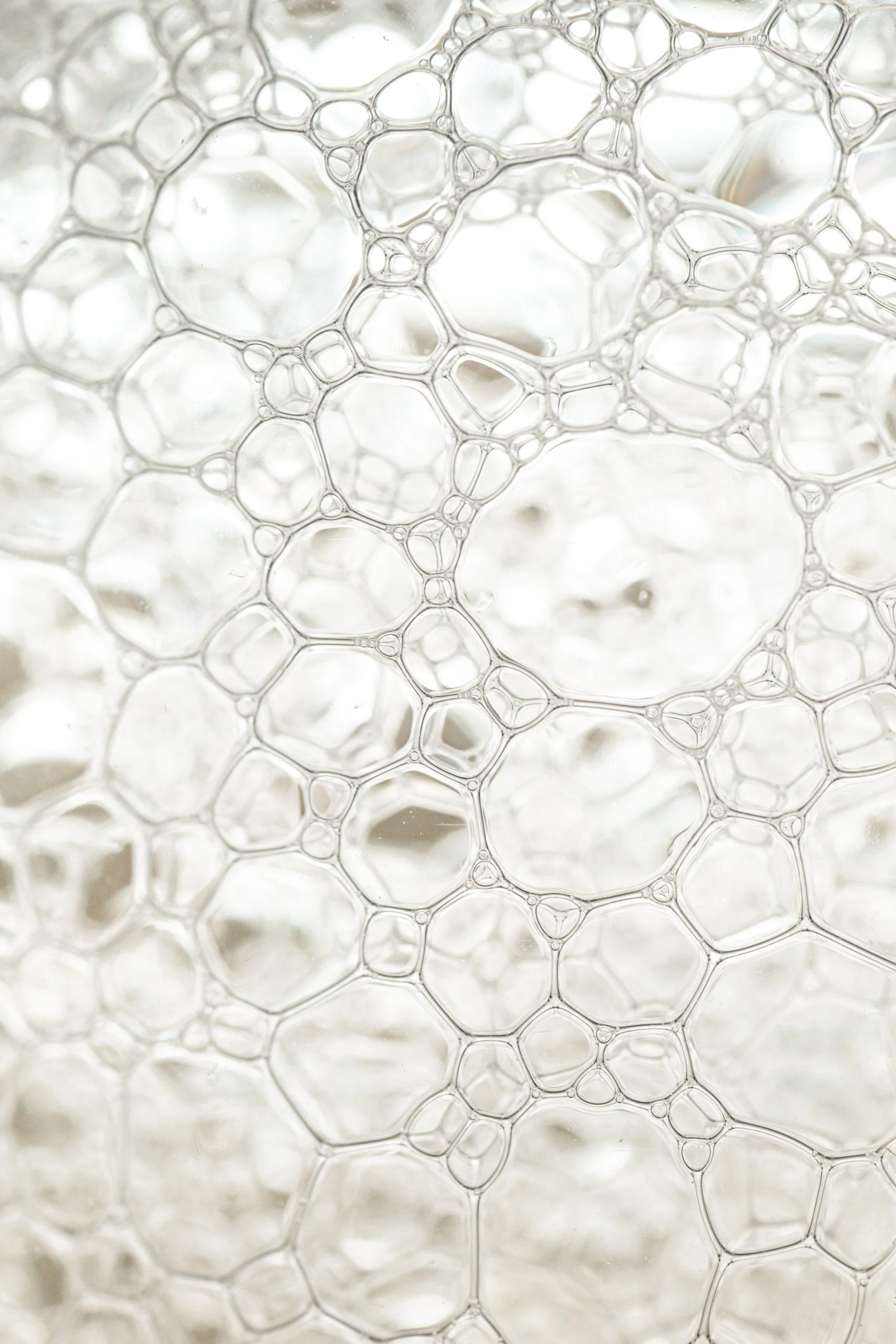 Close-up of white soap bubbles with interconnected circular patterns.