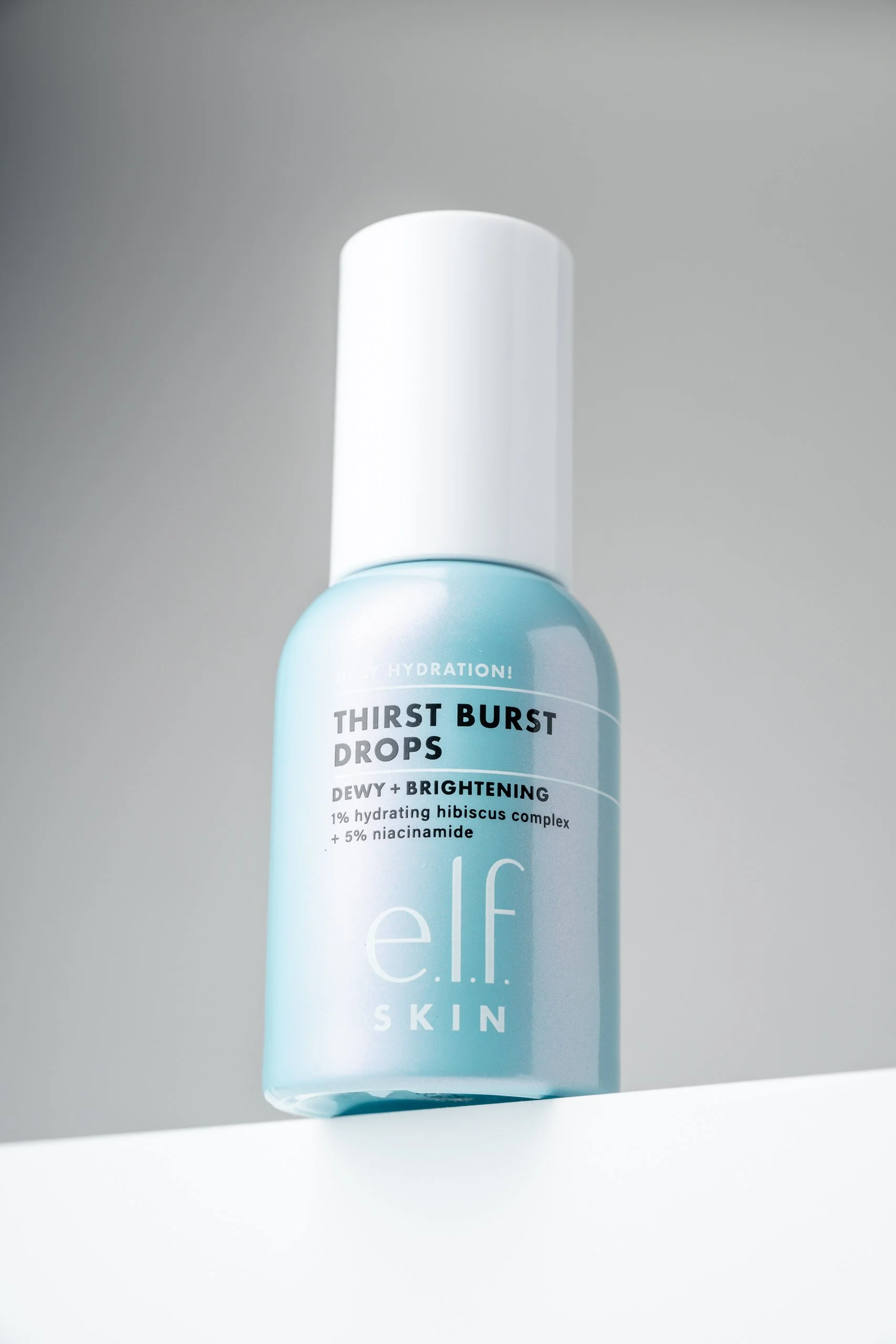 A light blue bottle of e.l.f. Skin Thirst Burst Drops with a white cap and minimalist label, positioned against a plain light background.