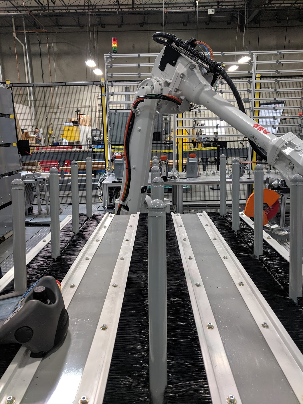 Industrial robotic arm working on a manufacturing line in a factory setting.