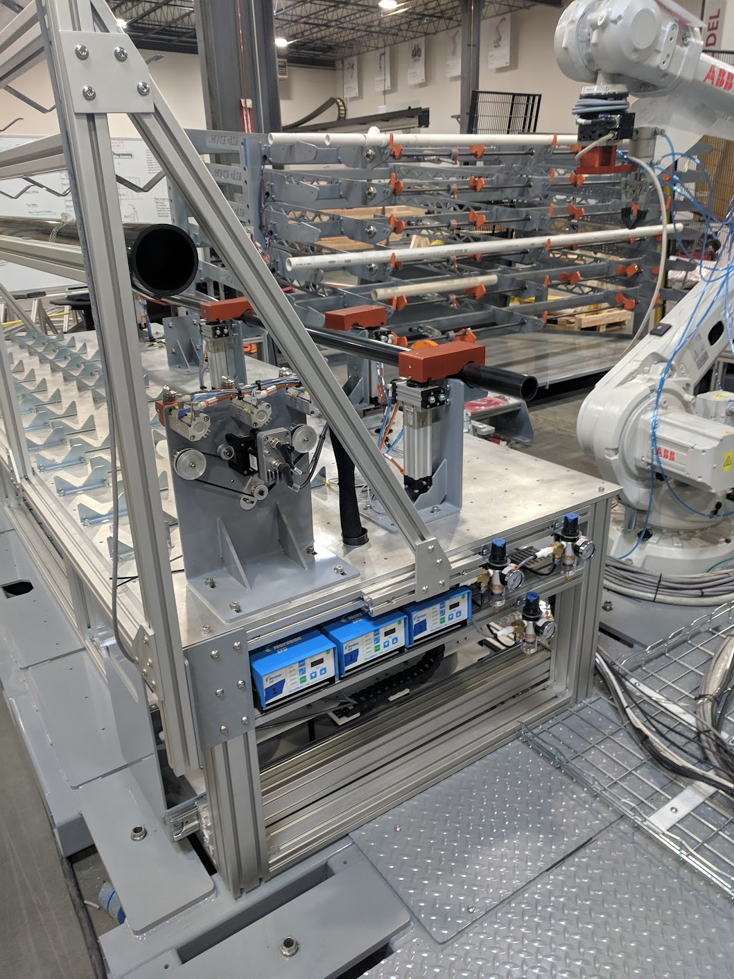 Close-up of industrial robotic machinery and automation equipment in a manufacturing facility, with mechanical arms, conveyor components, and electronic control units.