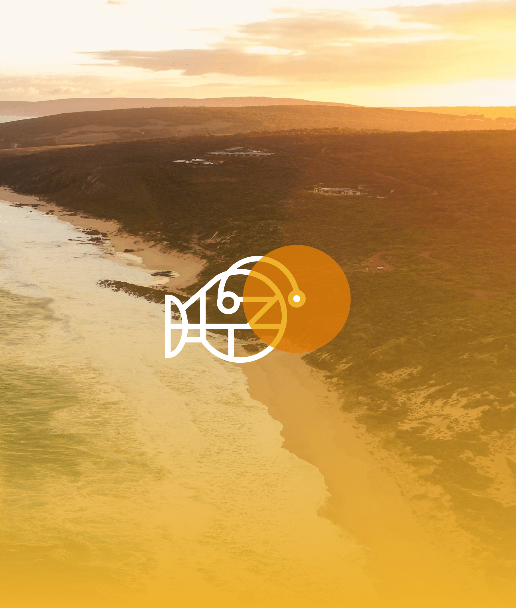 Sunset over coastal hills with a beach and ocean in the foreground.