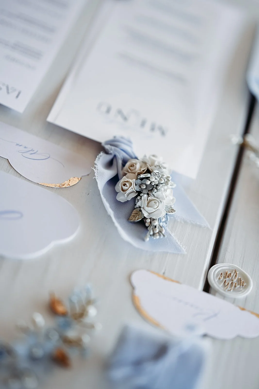 Hochzeitskarte mit Blumenapplikation, Briefumschläge und personalisiertem Briefpapier auf weißem Tisch.