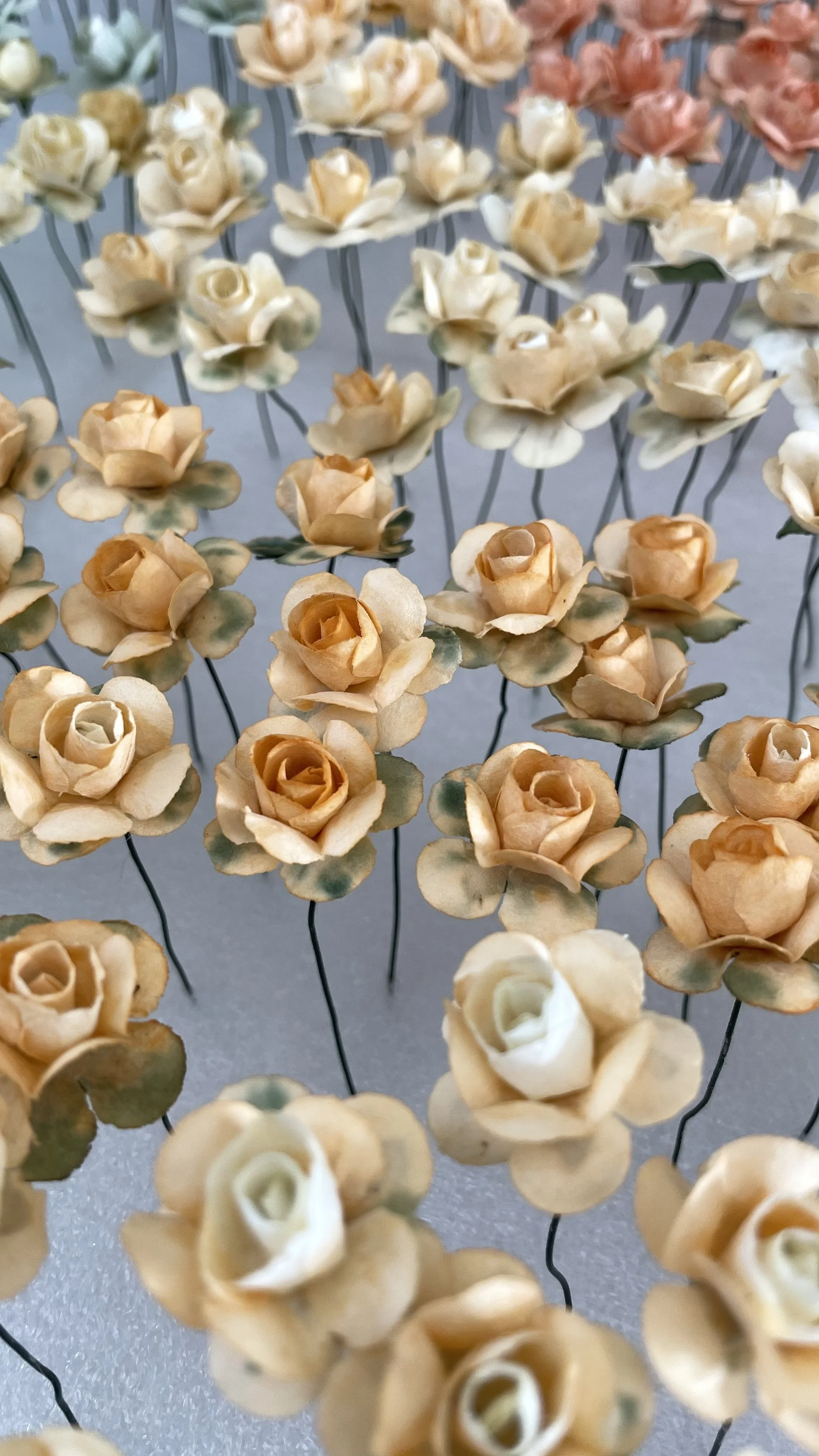 Kunstblumen in Form von Rosen in verschiedenen Pastellfarbtönen.