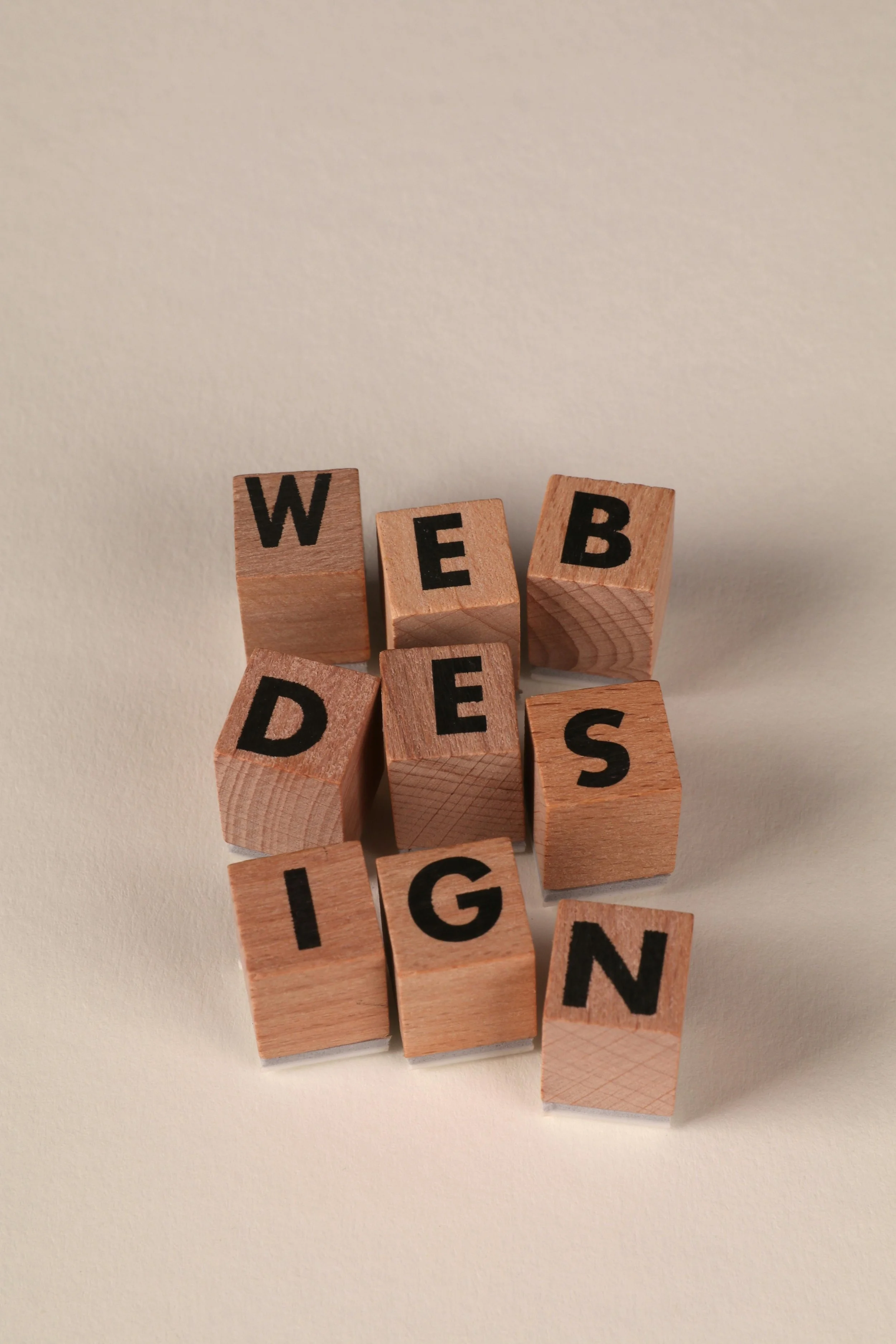 Multiple wooden blocks with black letters spelling out the word "WEBRIDGING".
