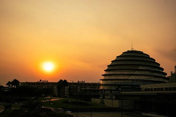 The iconic Kigali Convention Centre illuminated in vibrant green and orange lights at night, showcasing the modern architecture of Rwanda’s capital