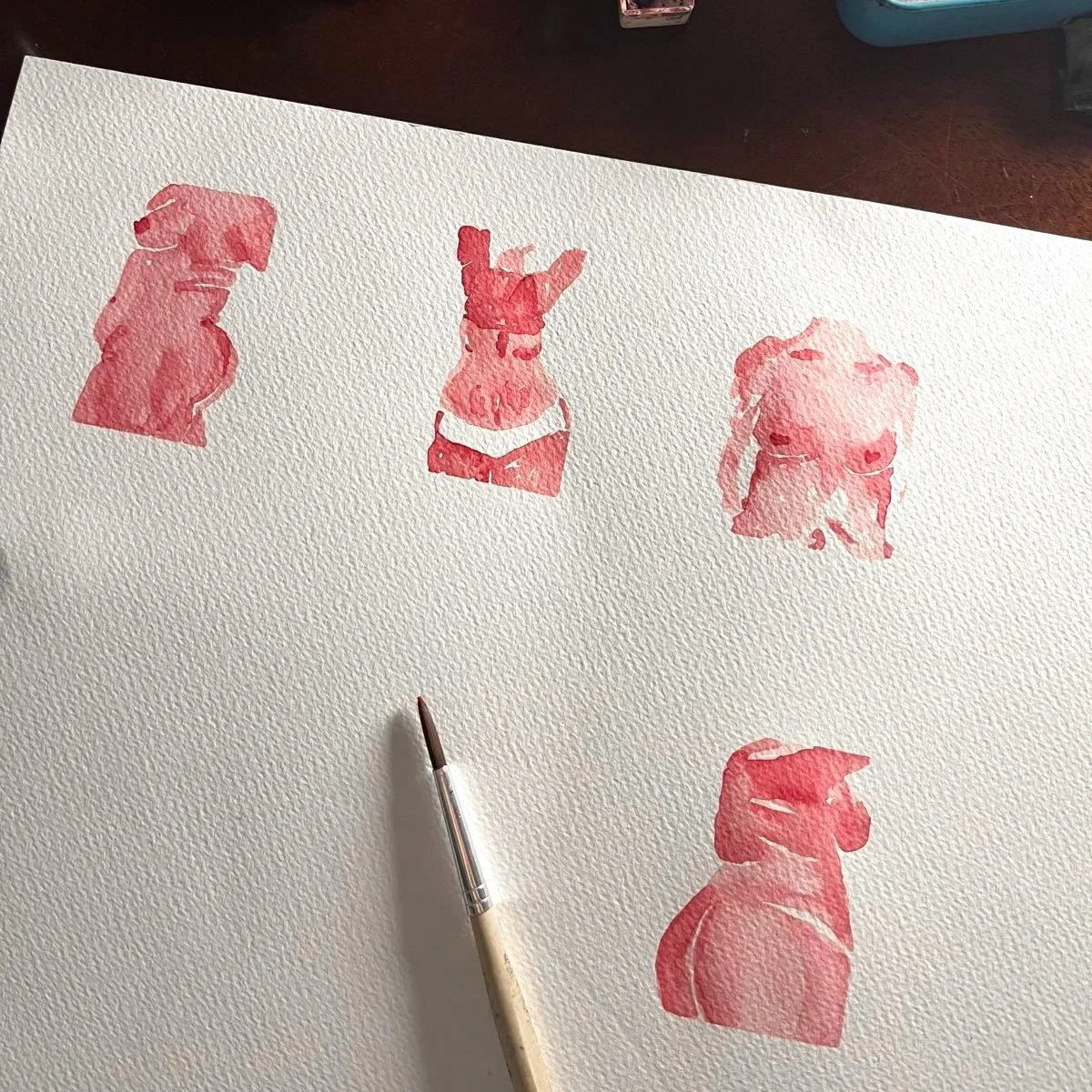 Vier rosa-rote, stilisierte Hundeskizzen auf einem weißen, strukturierten Papier, ein Pinsel liegt darunter.