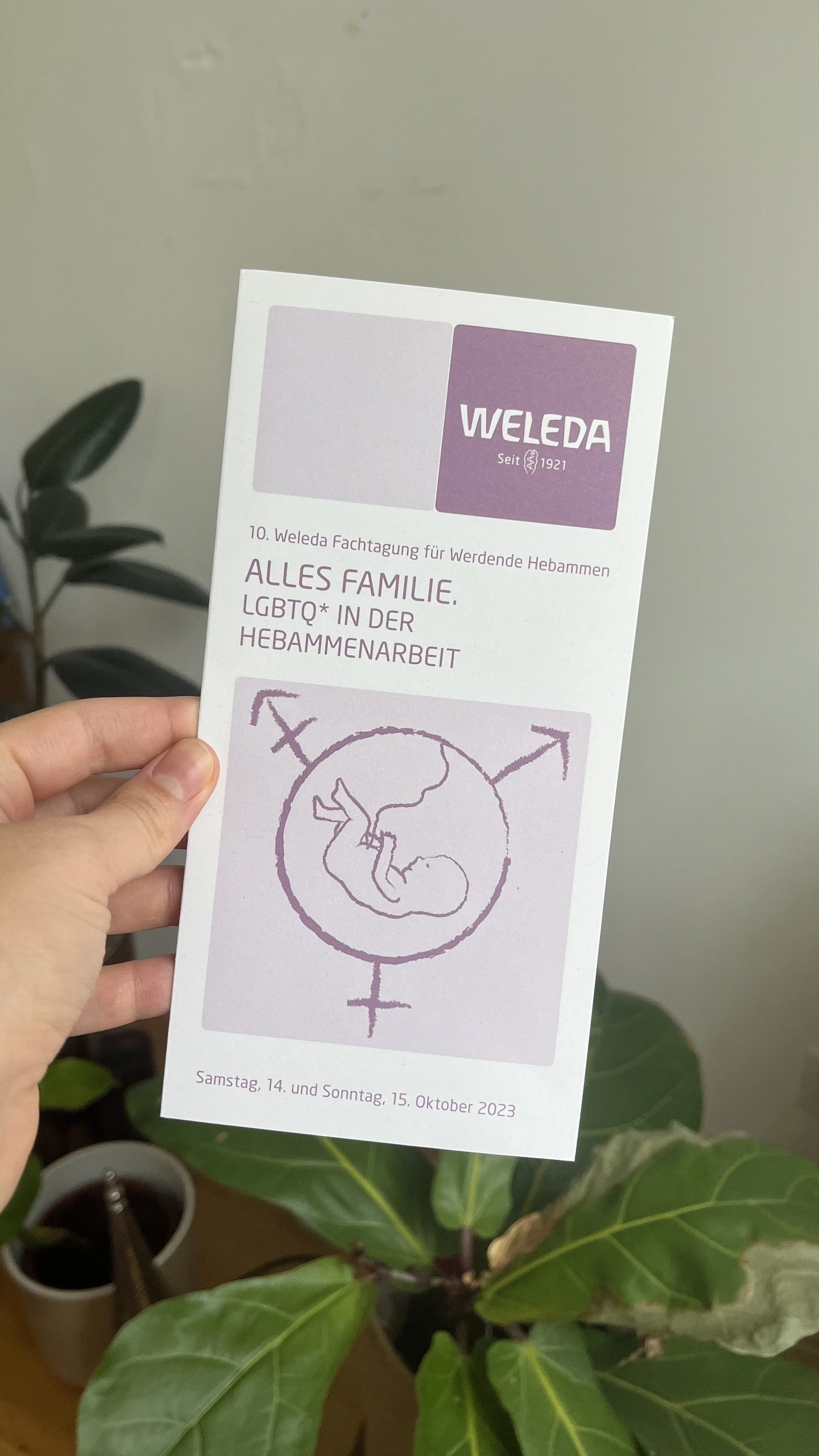 Flyer für eine Veranstaltung der Weleda am 14. und 15. Oktober 2023, mit einem feministischen Symbol, das eine schwangere Frau in einer Weltkugel zeigt, umgeben von weiblichen Symbolen.