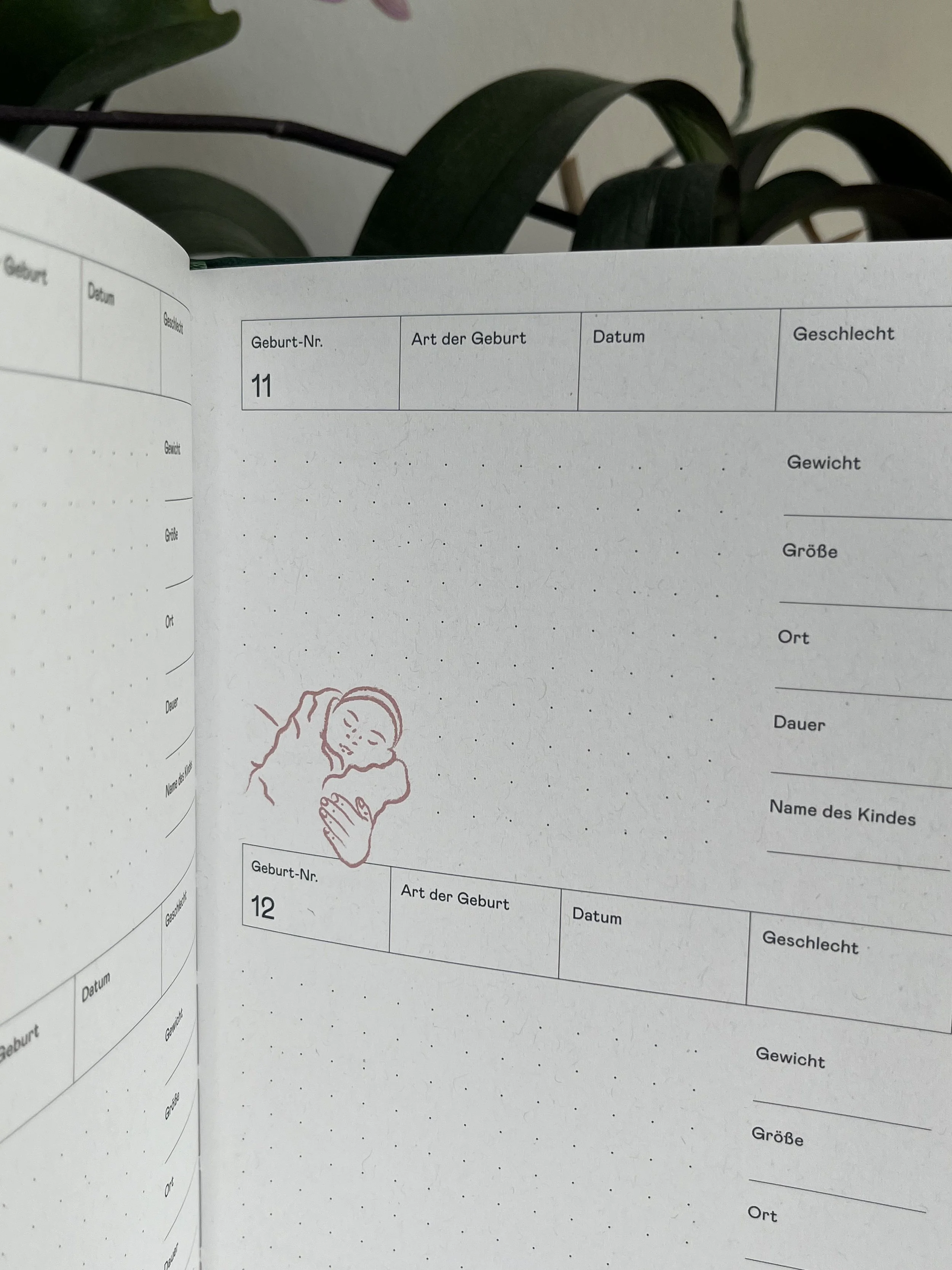 Ein Fotobuch mit Geburtsdaten und einer Zeichnung eines schlafenden Babys.