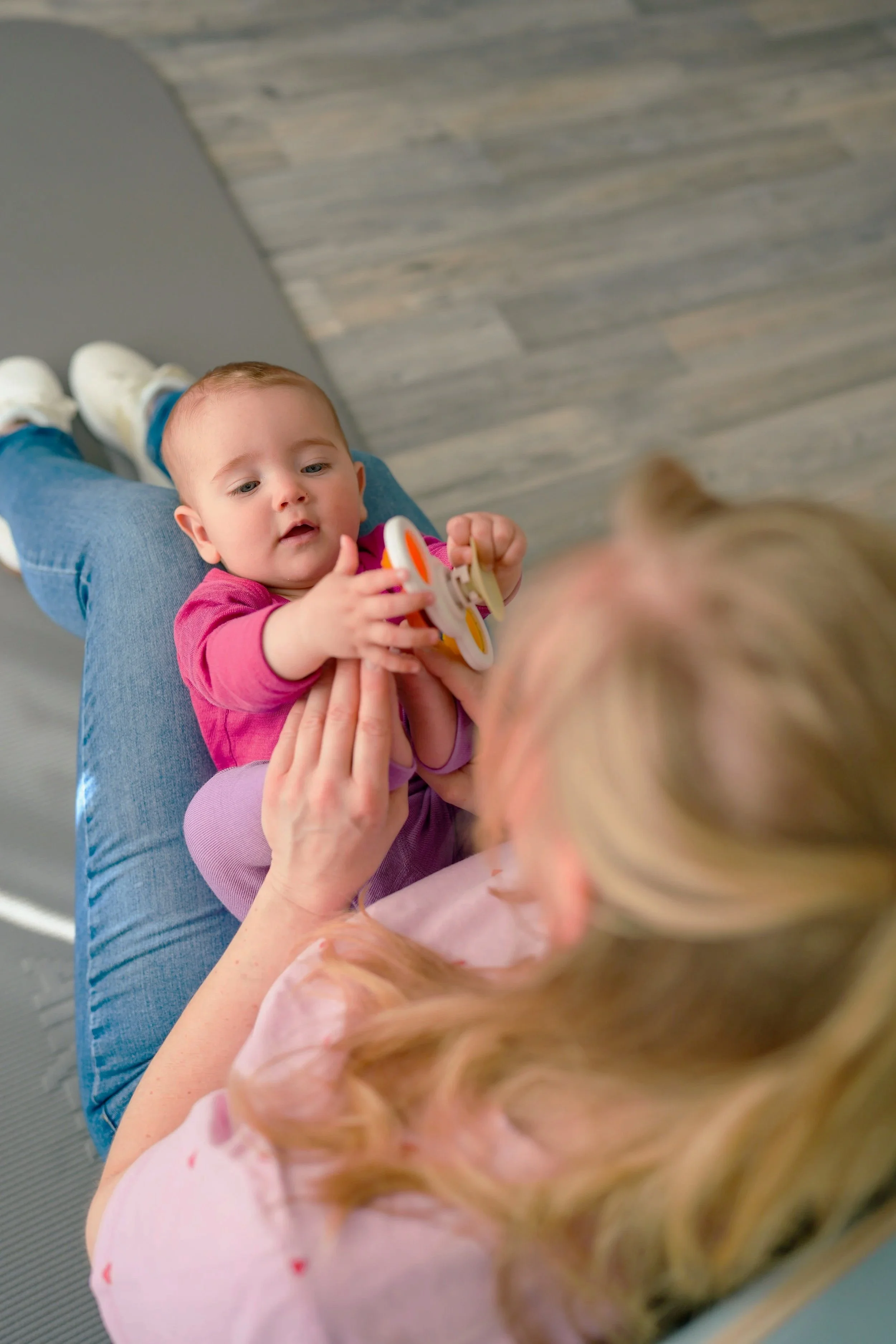 Baby auf Schoß der behandelnden Physiotherapeutin