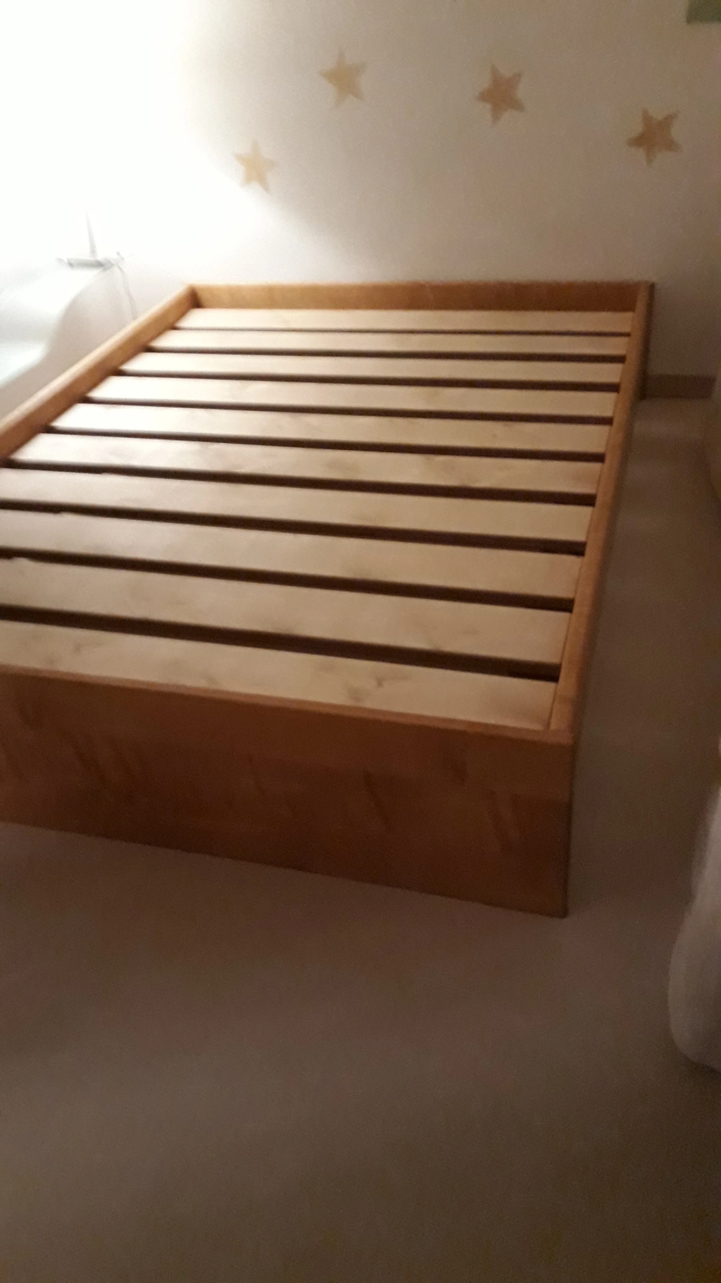 Wooden bed slats in a room with star-shaped wall decorations.