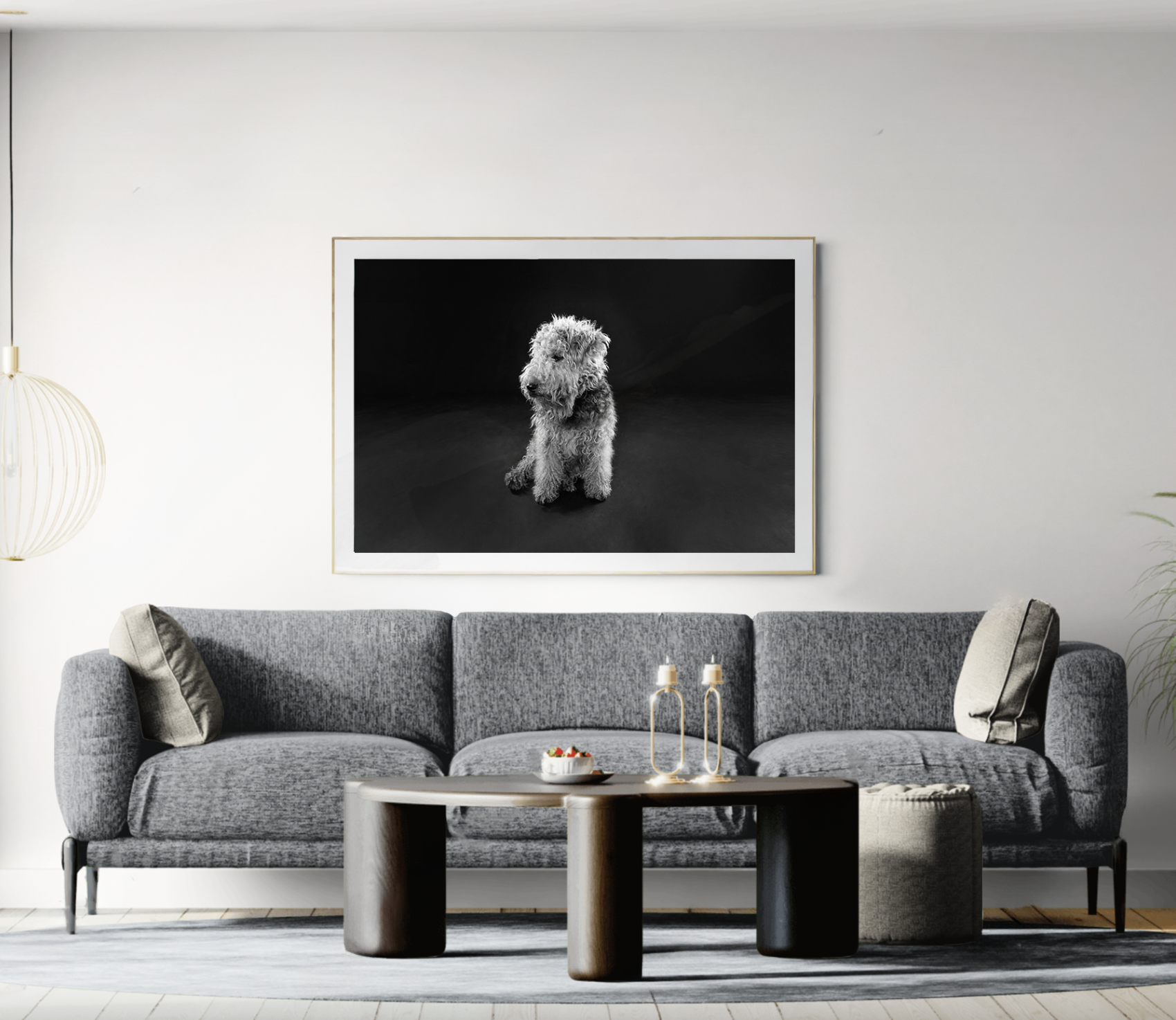 Living room with gray sofa, abstract black and white dog portrait on wall, coffee table with candles, and modern decor.