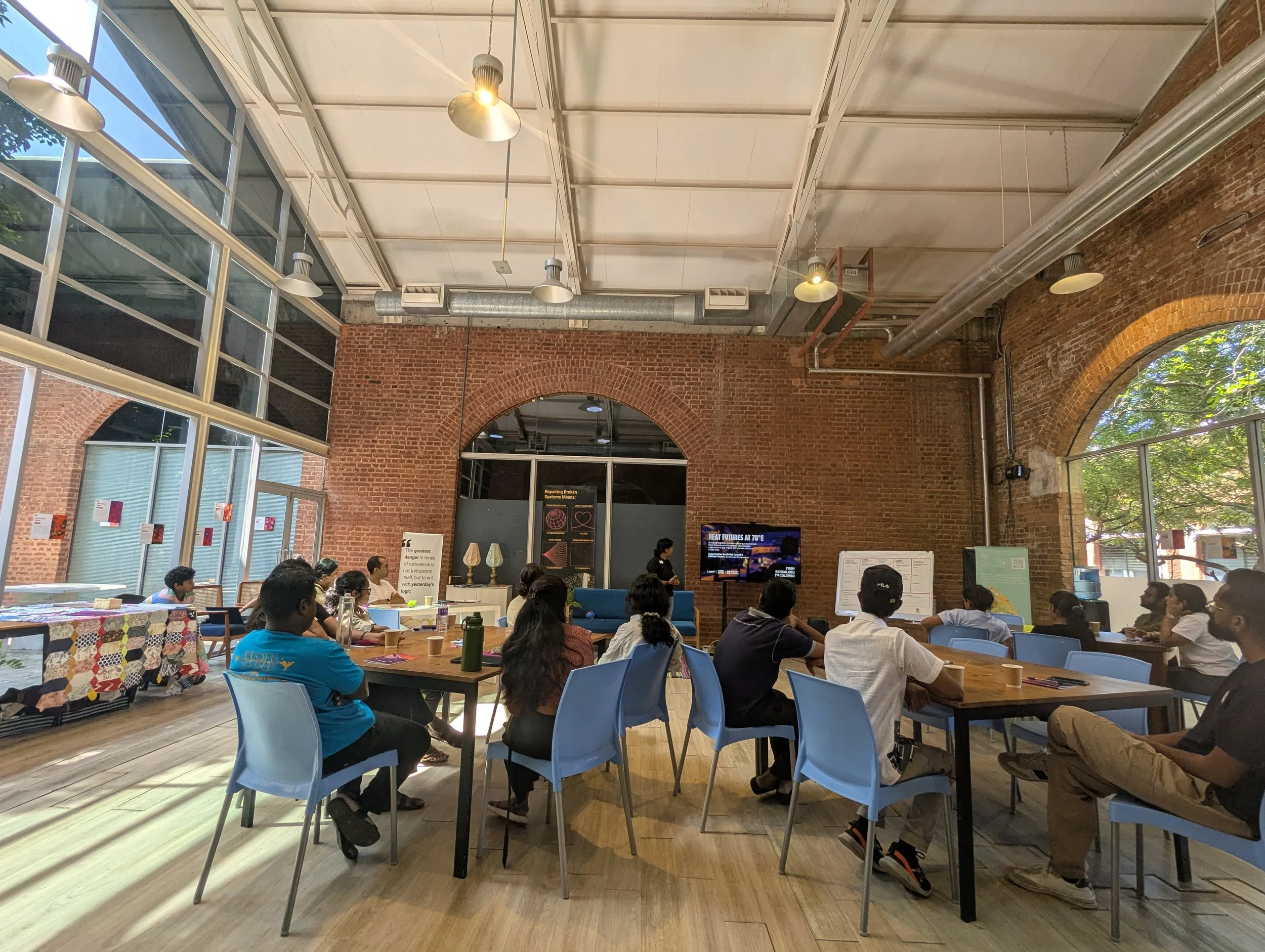 Interdisciplinary cohort gathered for a plenary session during Heat Futures at 78°E by Lagori Collective and Good Life X, supported by British Council, with the programme slide visible on screen in Bengaluru.