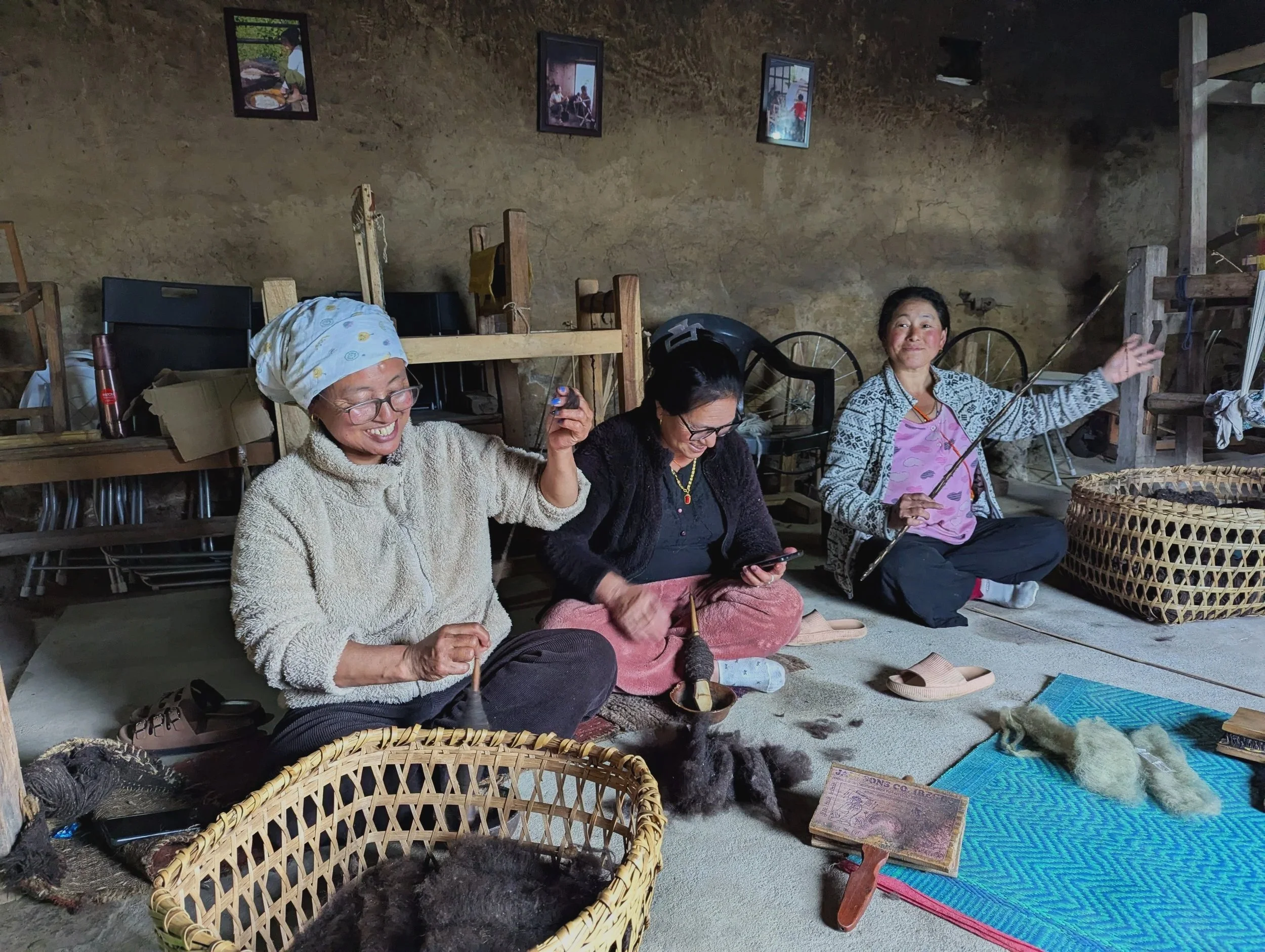 Brokpa women from the Monpa community in Arunachal Pradesh spinning yak wool together indoors, during field research for the Norbu Governance Futures project by Lagori Collective and It's All Folk.