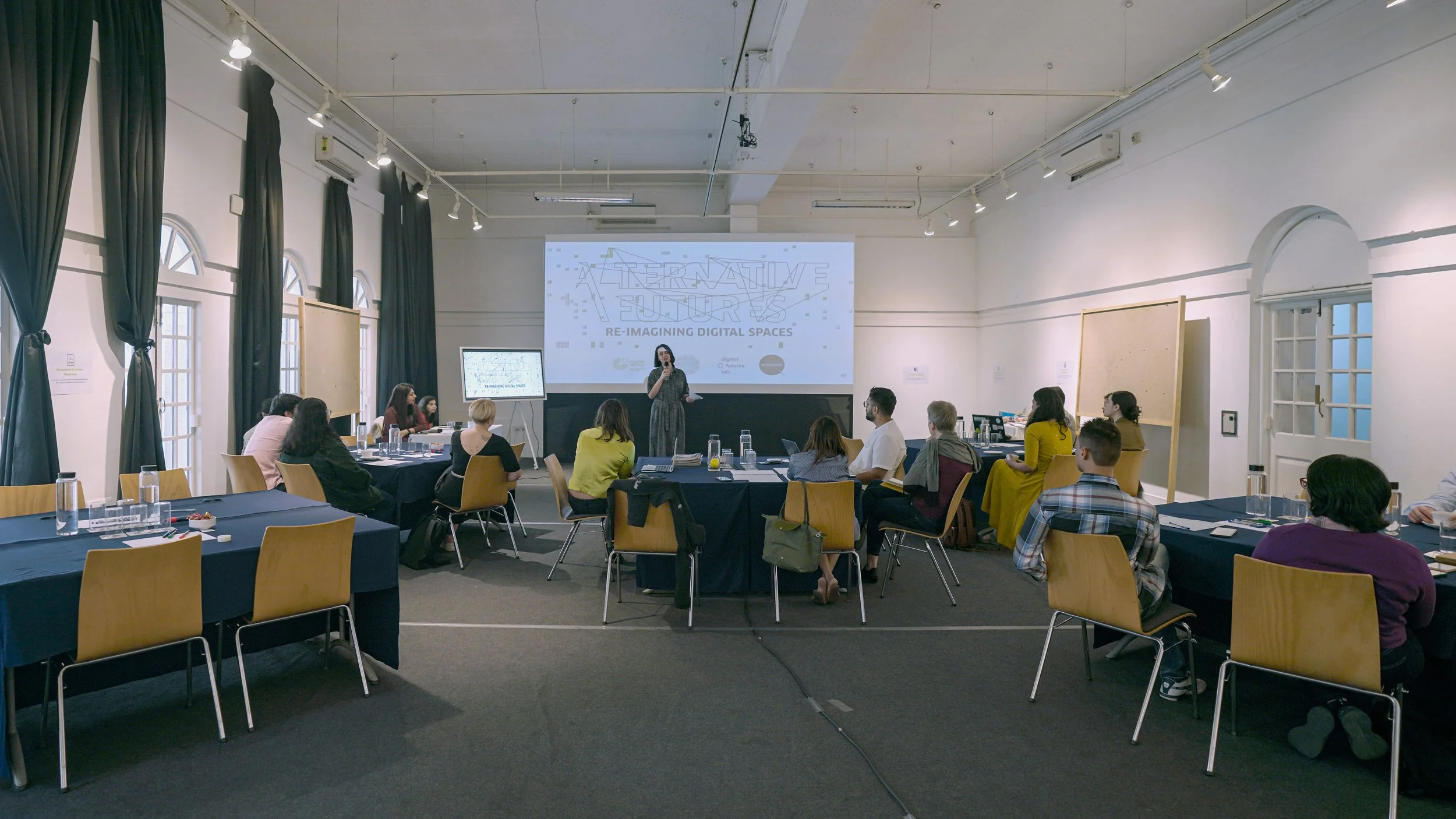 Plenary session during the Alternative Digital Futures workshop by Lagori Collective, and Superrr Lab, with Alternative Futures Re-imagining Digital Spaces projected on screen.