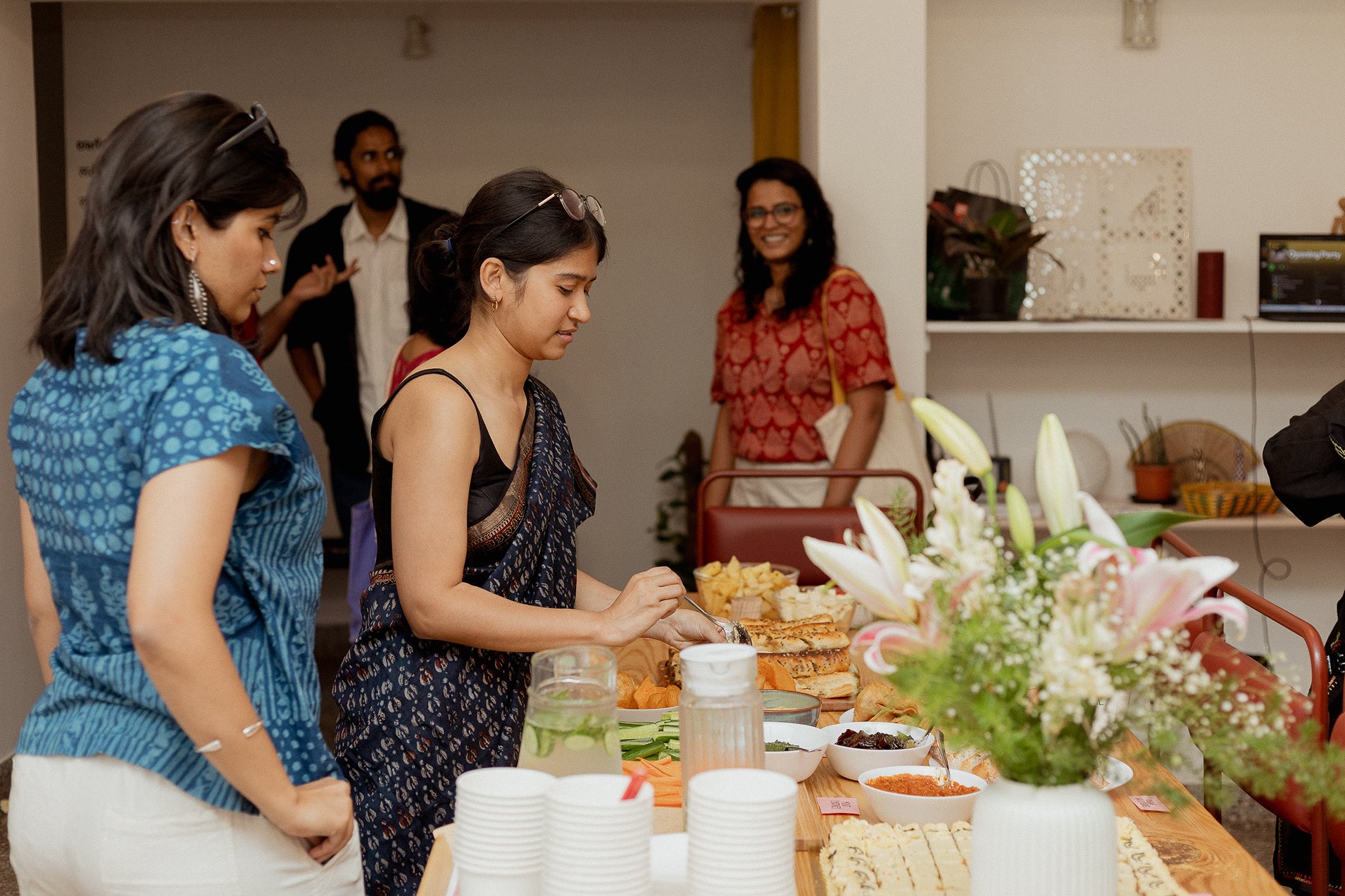 Members and guests at a community gathering at Lagori Collective's cooperative workspace in Bengaluru, gathered around a shared spread during a community event.