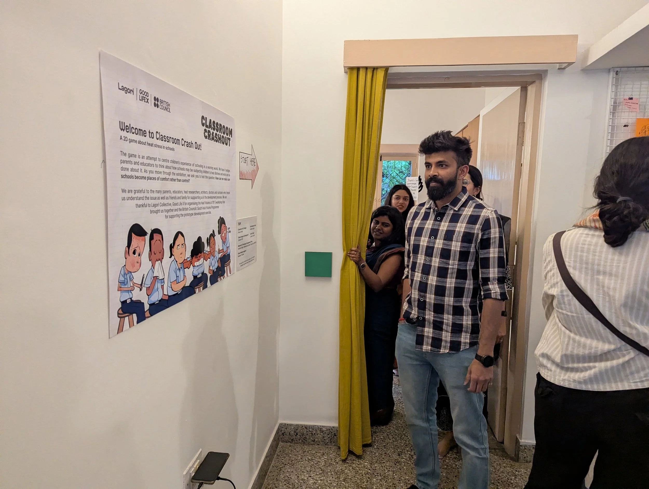 Visitors entering the Heat Futures at 78°E public exhibition at Lagori Collective in Bengaluru, with a Classroom Crashout game poster visible at the entrance, a prototype developed during the programme.