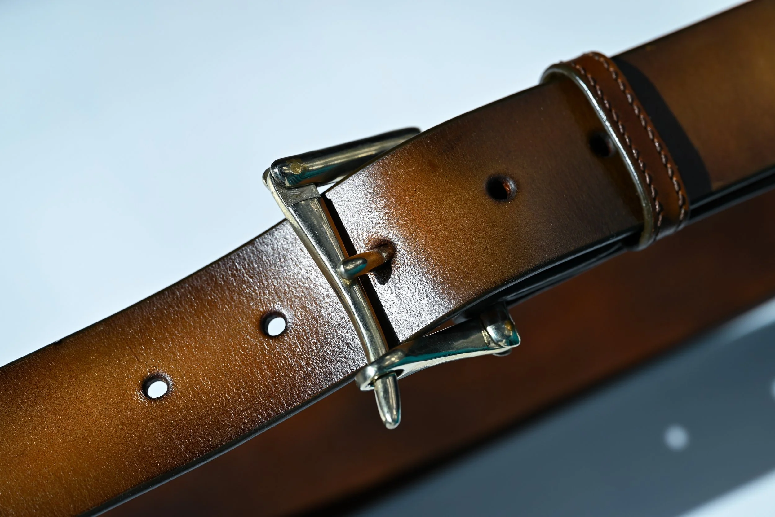 Une ceinture en cuir tanné végétal patiné avec une boucle de pompier