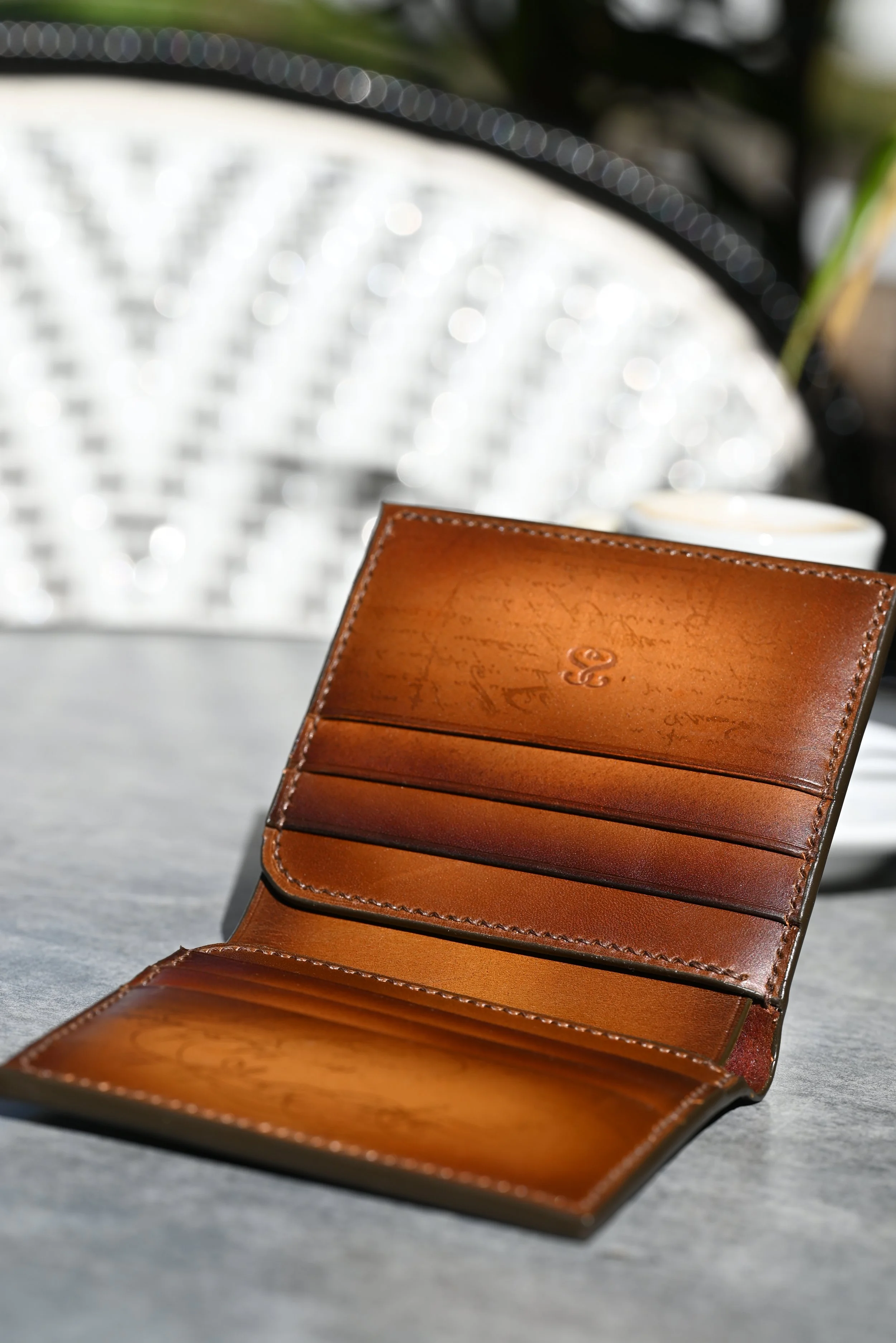 Portefeuilles en cuir tanné végétal patiné à la main posé sur une table grise