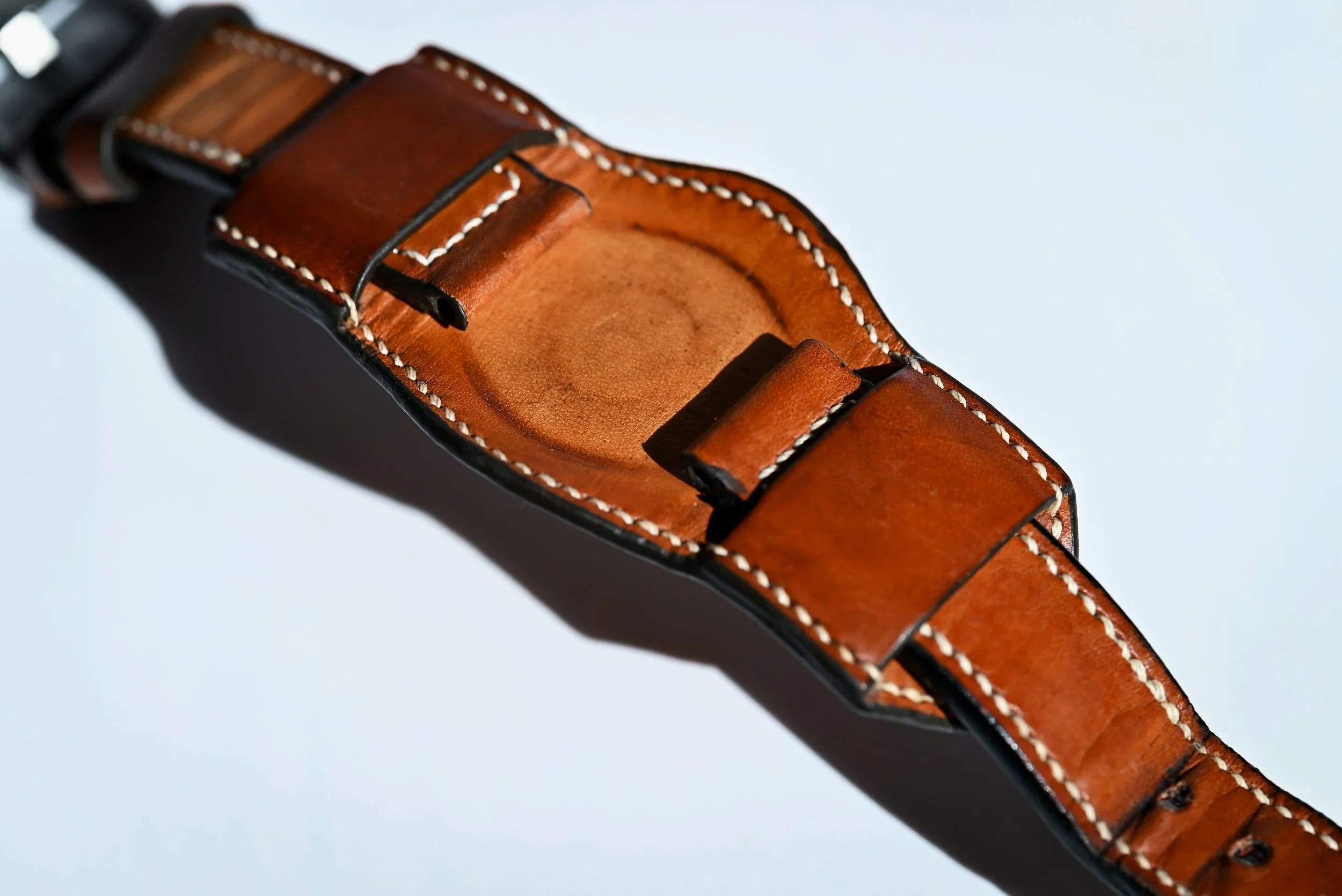 Un bracelet de montre de style bund en cuir tanné végétal naturel patiné par le temps