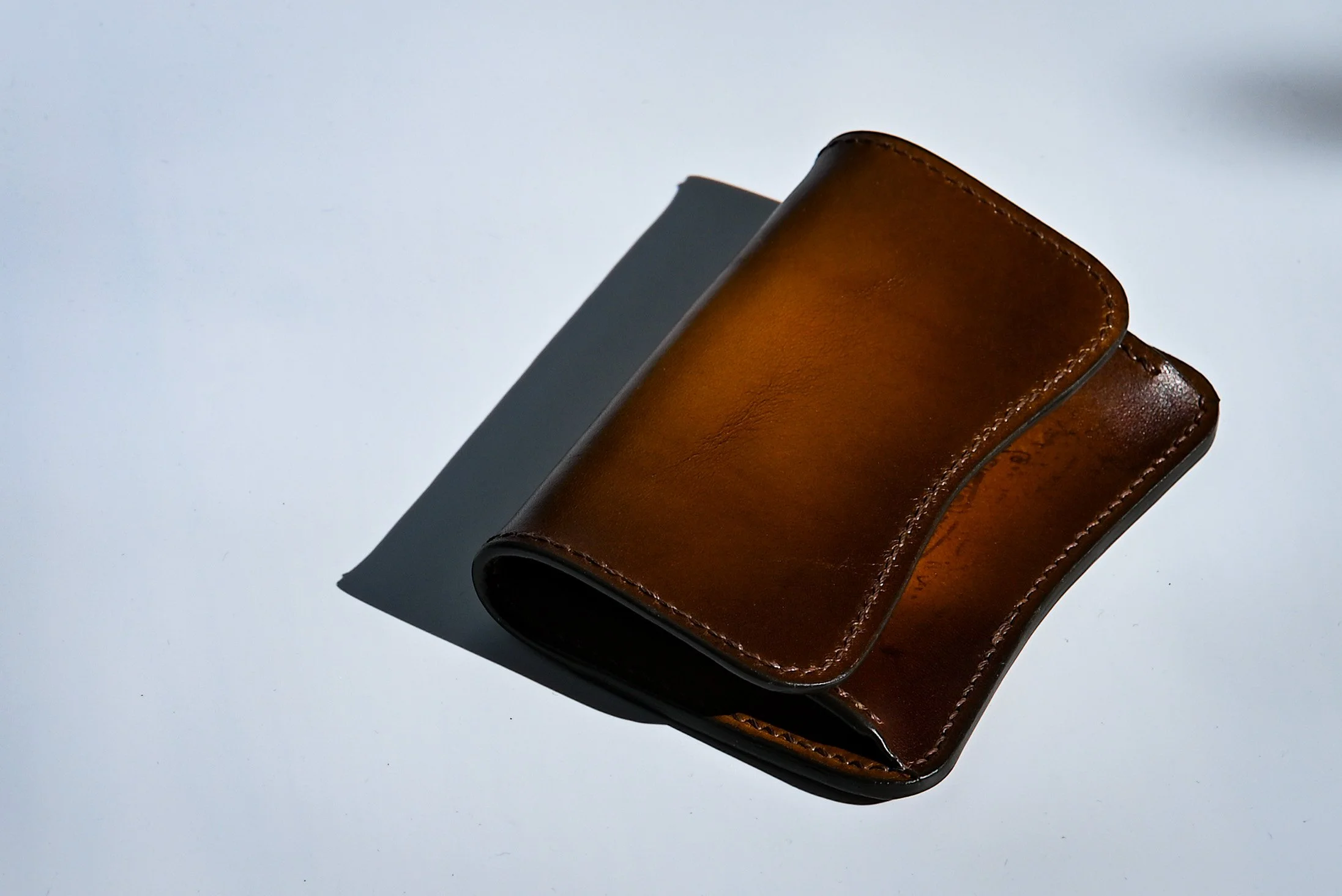 Portefeuille en cuir marron sur fond blanc avec ombre