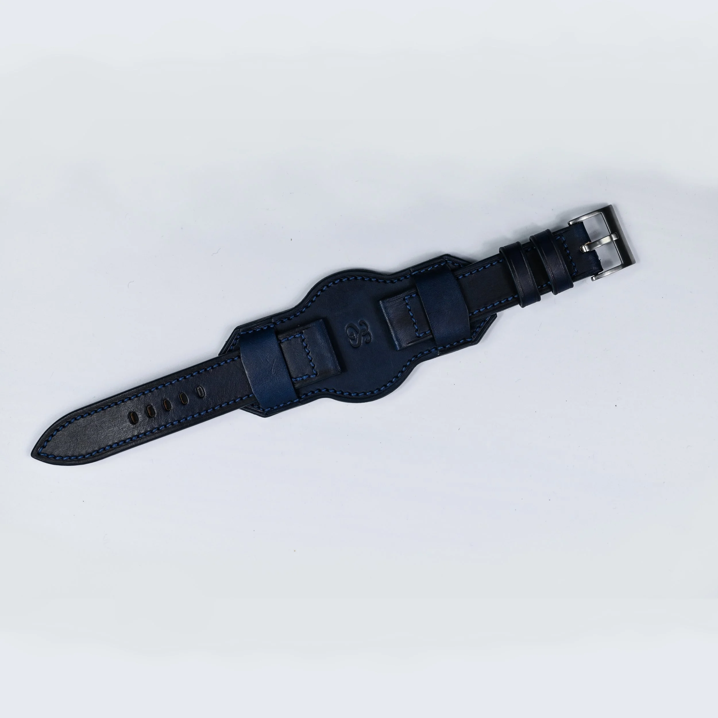 Ceinture en cuir noir avec boucle métallique, posée à plat sur un fond blanc.