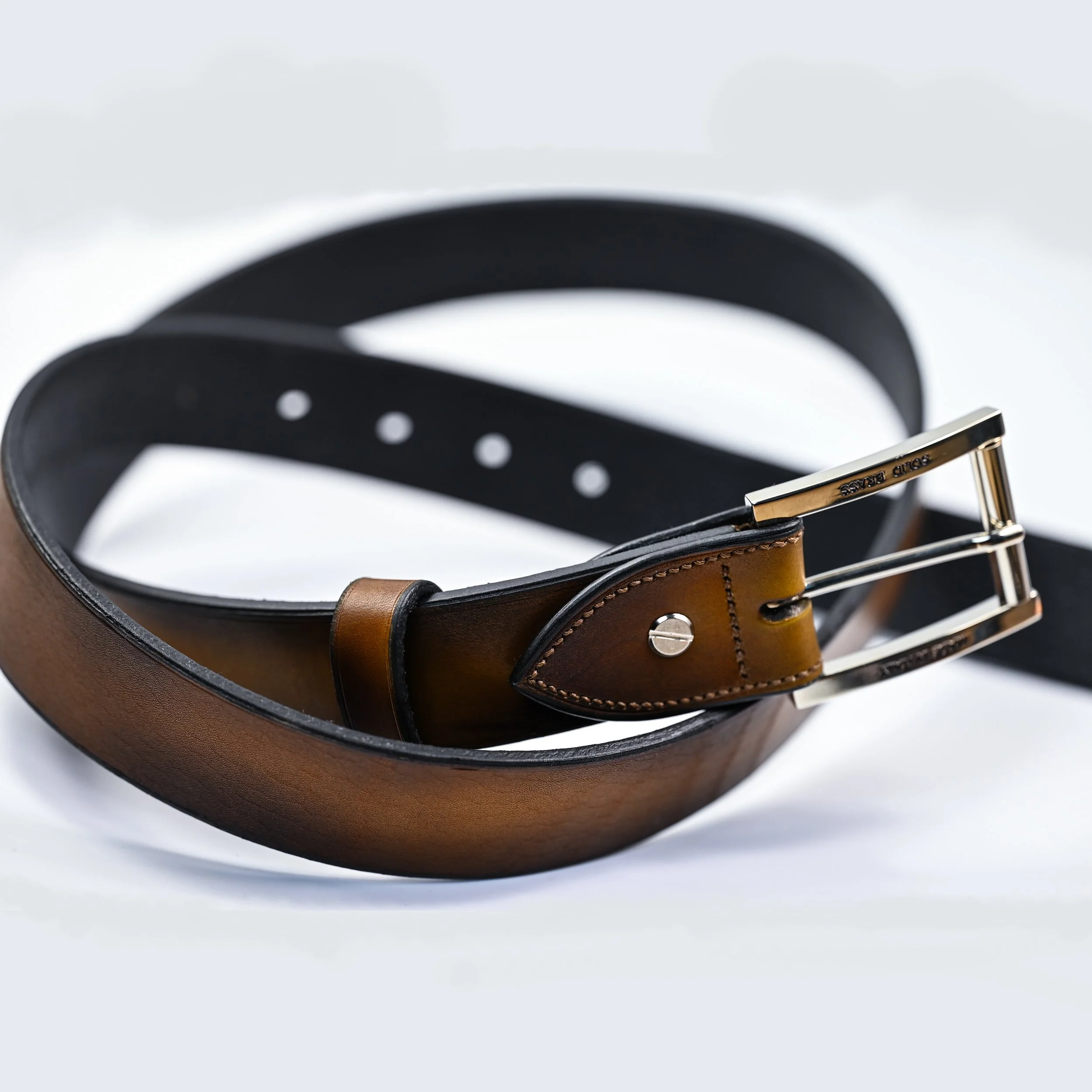 Ceinture en cuir marron avec boucle en métal doré, sur fond blanc.