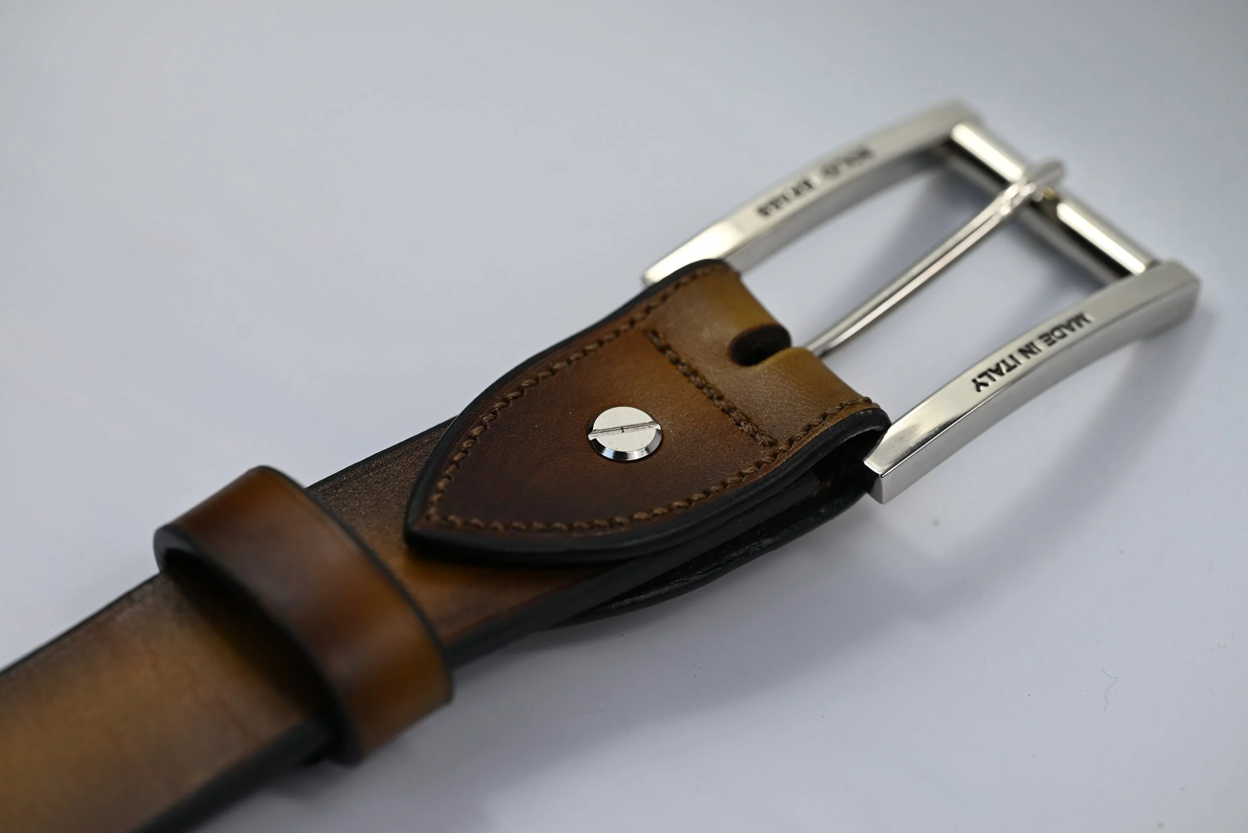 Ceinture en cuir marron avec boucle en métal argenté, marquée 'MADE IN ITALY', vue de côté