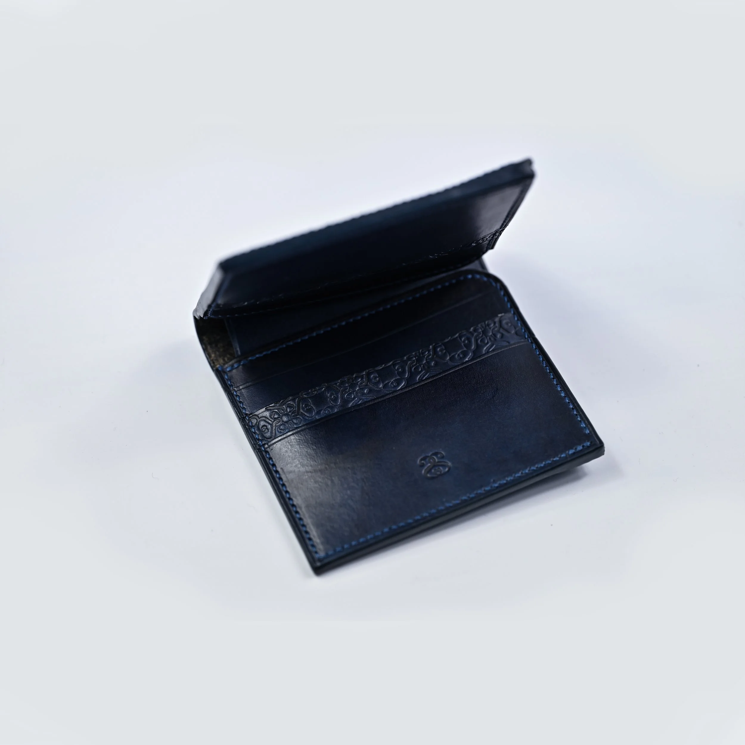 Portefeuille en cuir noir ouvert sur fond blanc.