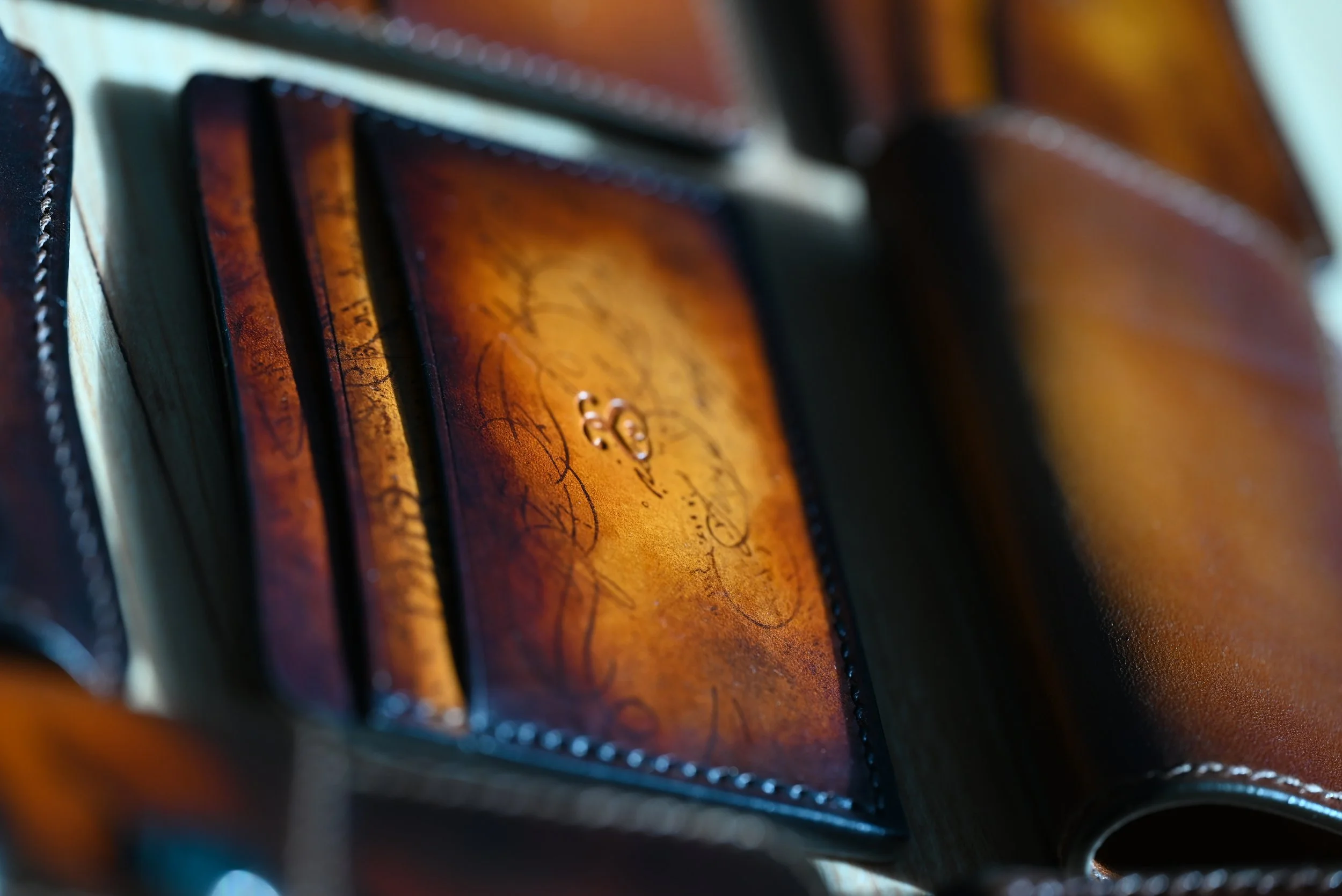 Cuir de haute qualité avec signatures ou inscriptions manuscrites, pliures et coutures visibles, probablement une pièce de maroquinerie ou un portefeuille en cuir