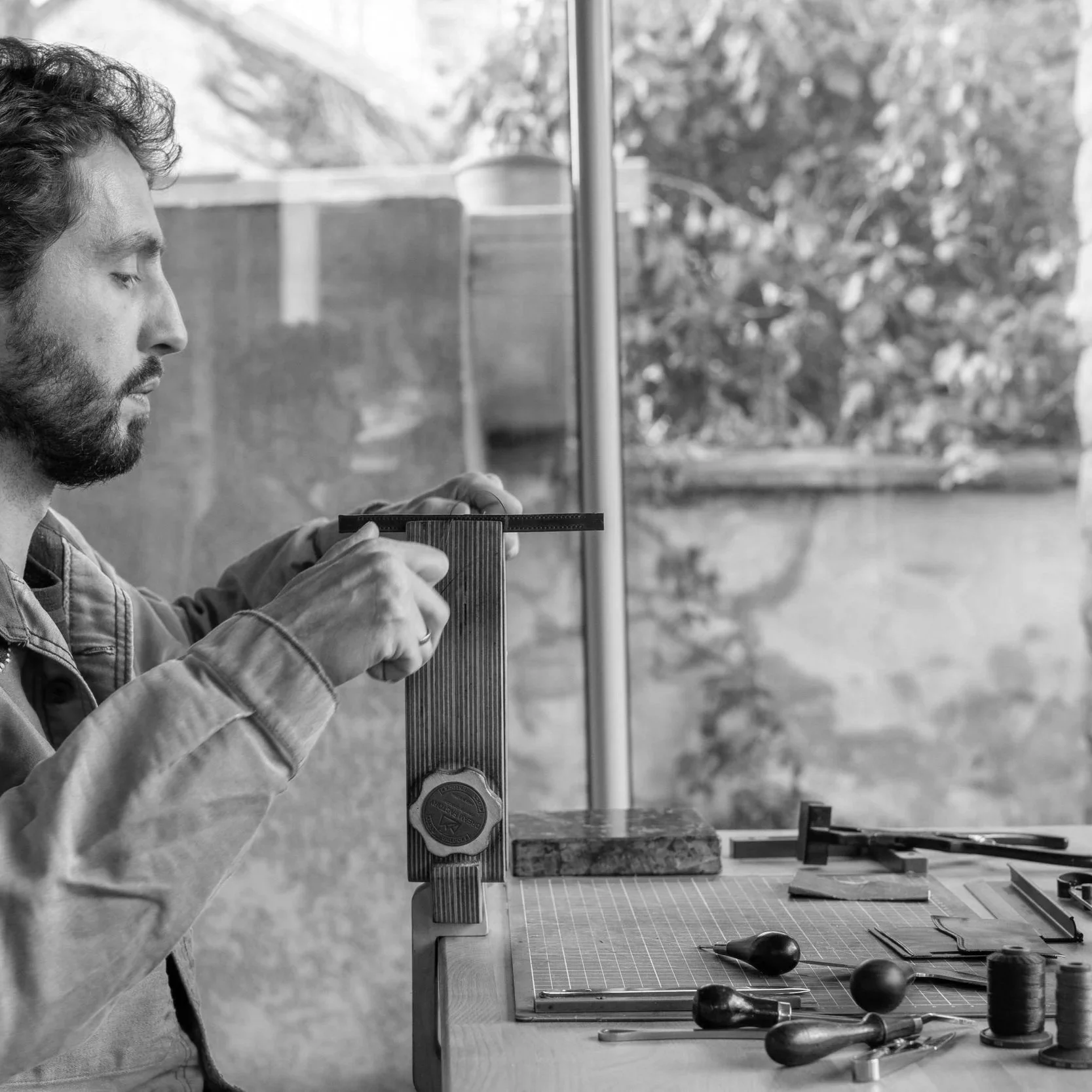 Un homme travaille sur un projet de bricolage à la table avec divers outils, vue d'ensemble