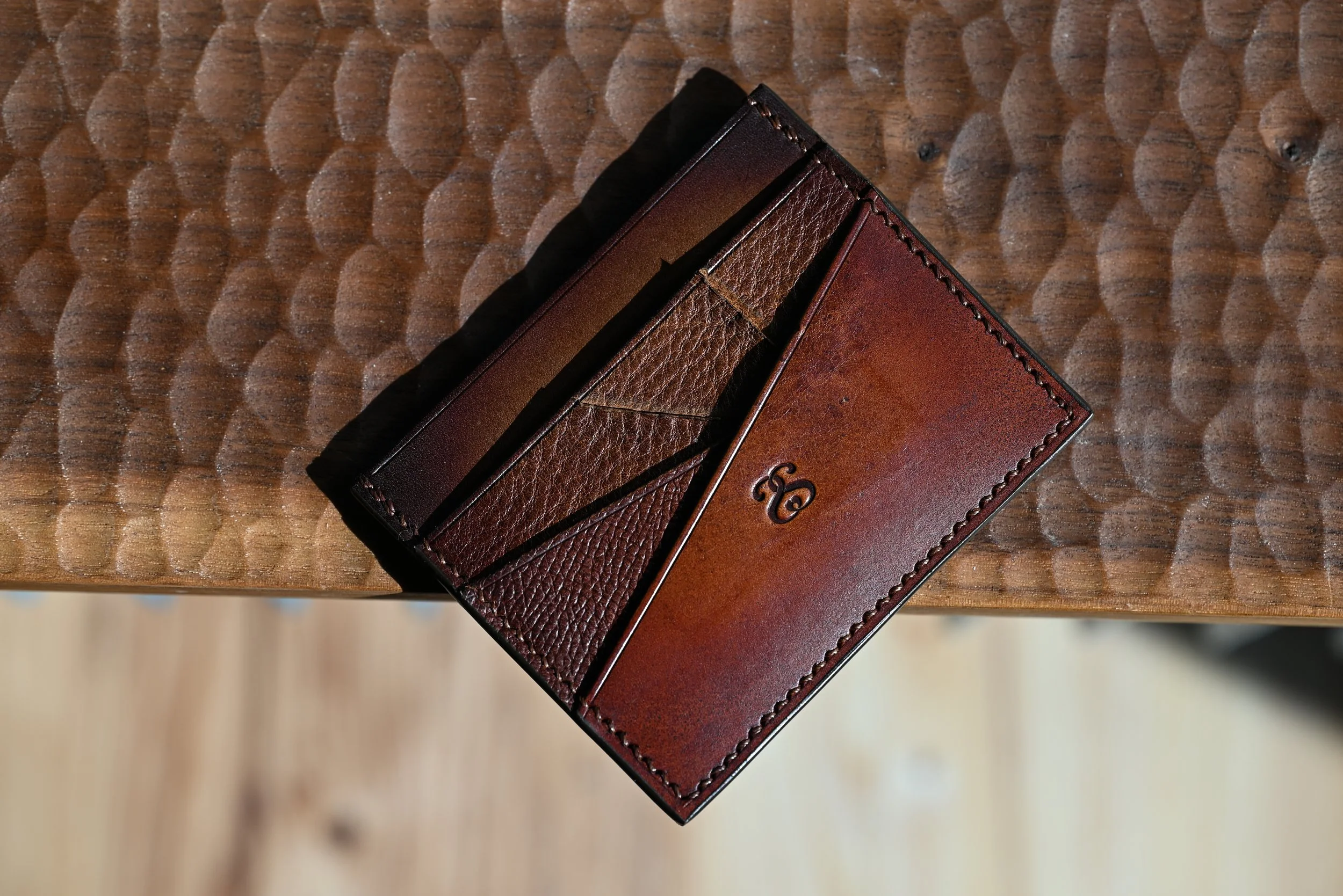 Portefeuille en cuir marron posé sur une table en bois.