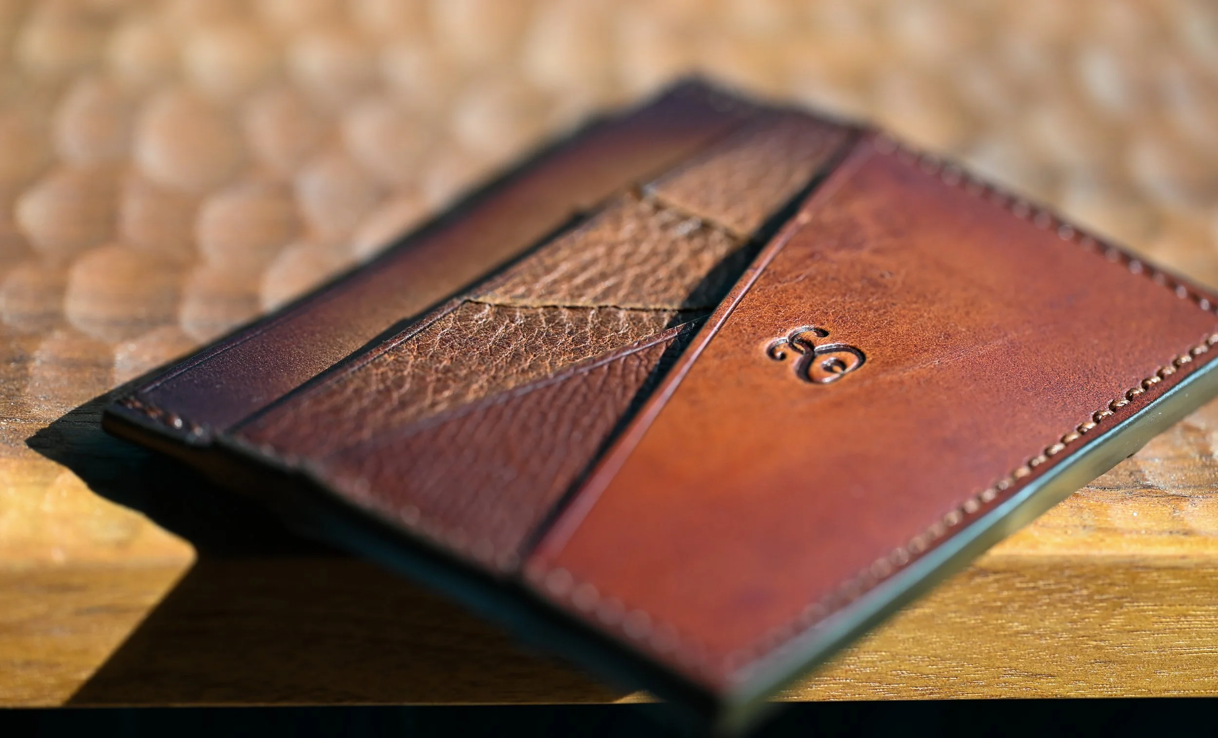 Portefeuille en cuir marron posé sur une surface en bois avec lumière naturelle.