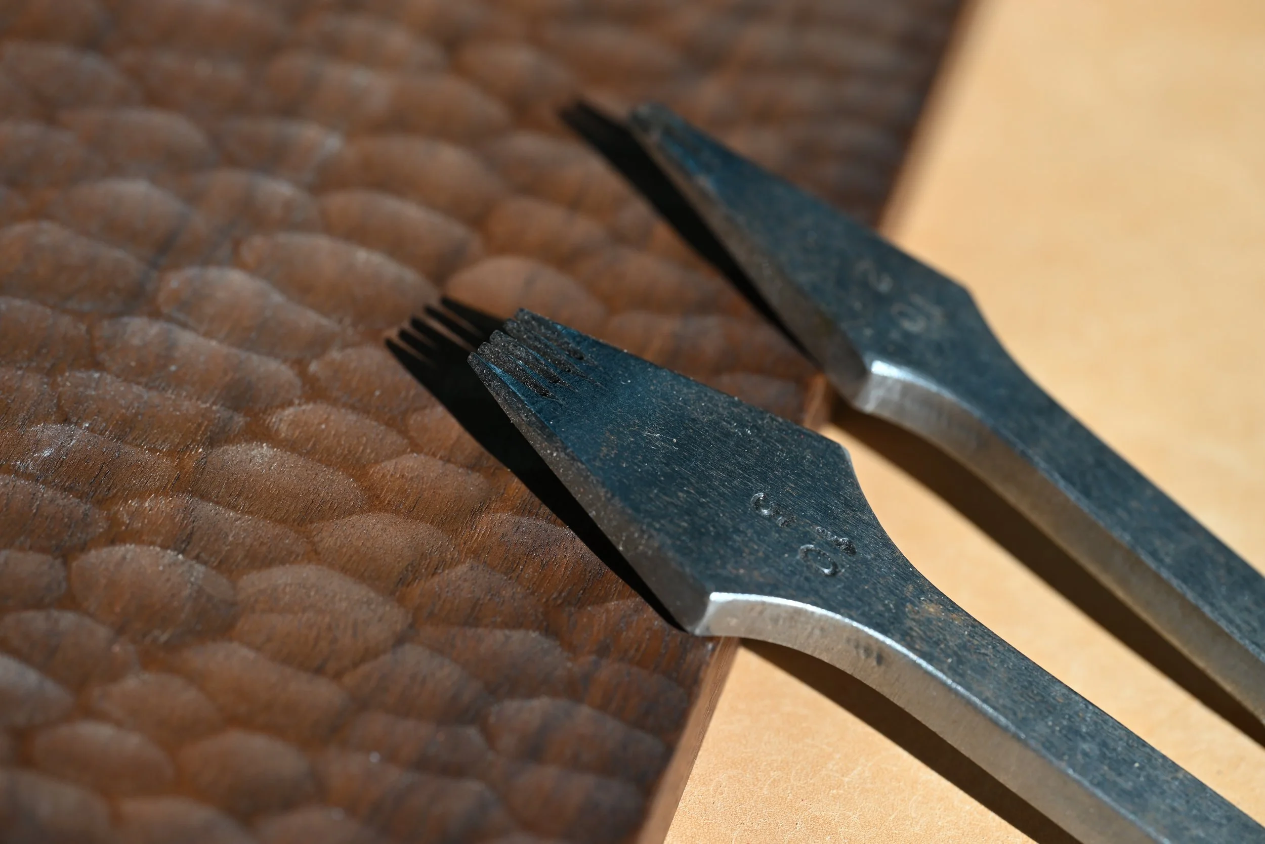 Deux fourchettes en métal posées sur une surface en bois à motif de cercle
