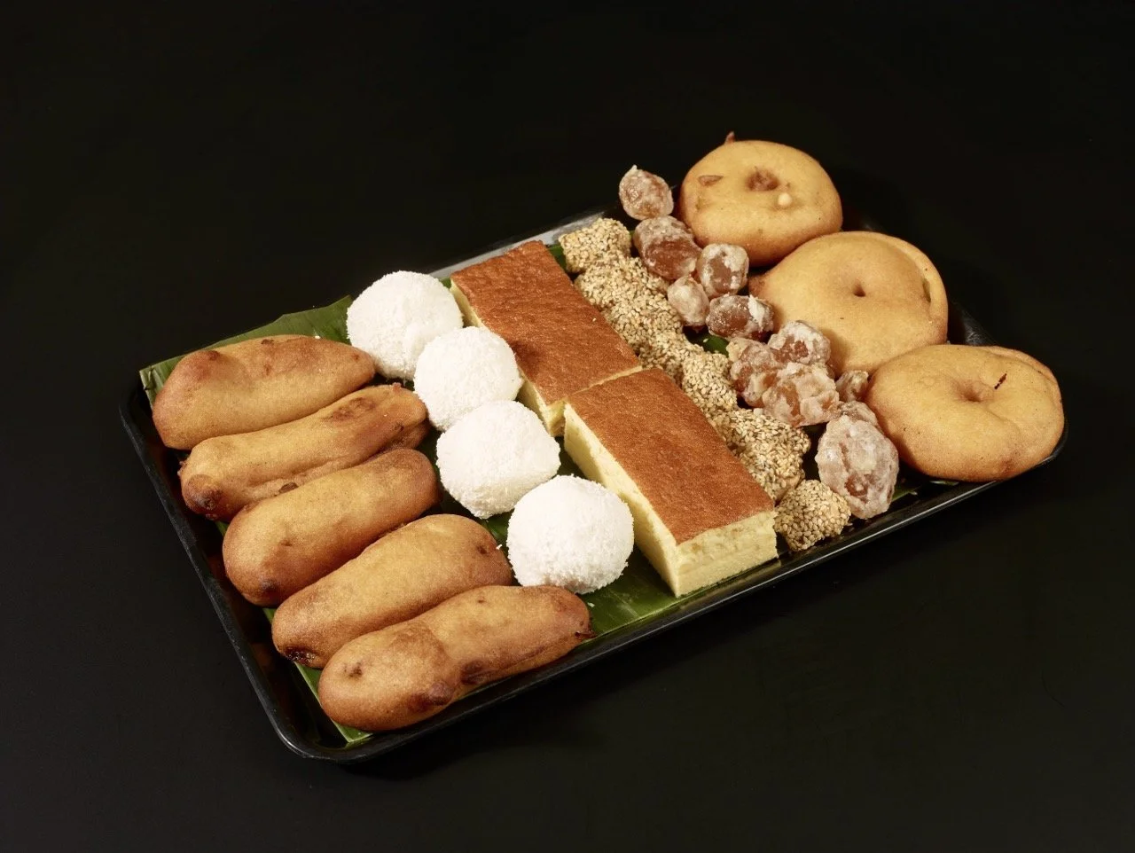Assortiment de pâtisseries et biscuits traditionnels en pose sur un plateau noir
