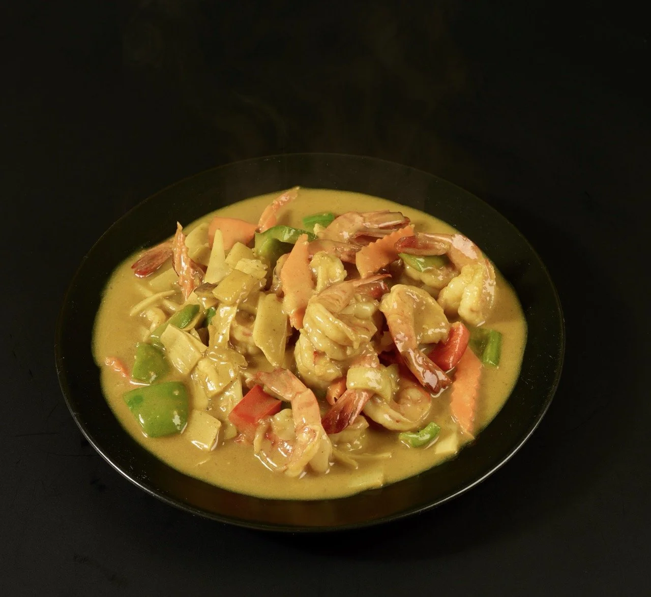 Plat de crevettes, légumes variés dans une sauce jaune