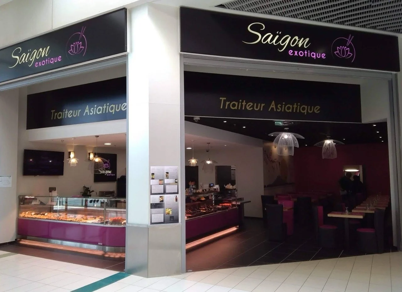 Restaurant nommé Saigon exotique, proposant une cuisine asiatique, avec une vitrine de plats et un espace intérieur avec tables et chaises.