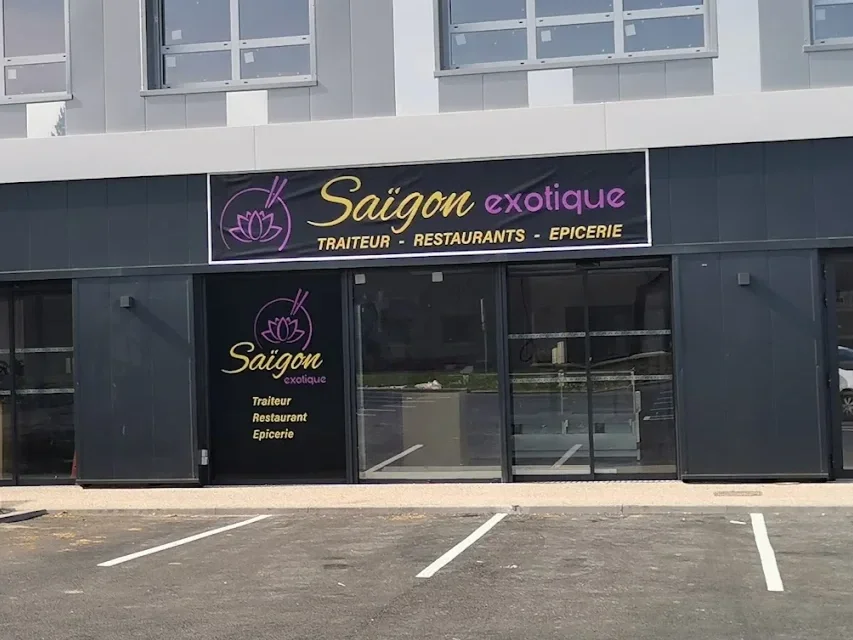 Façade d'un restaurant appelé Saïgon exotique, proposant traiteur, restaurants et épicerie, avec une enseigne avec écrit en français dans un bâtiment moderne.